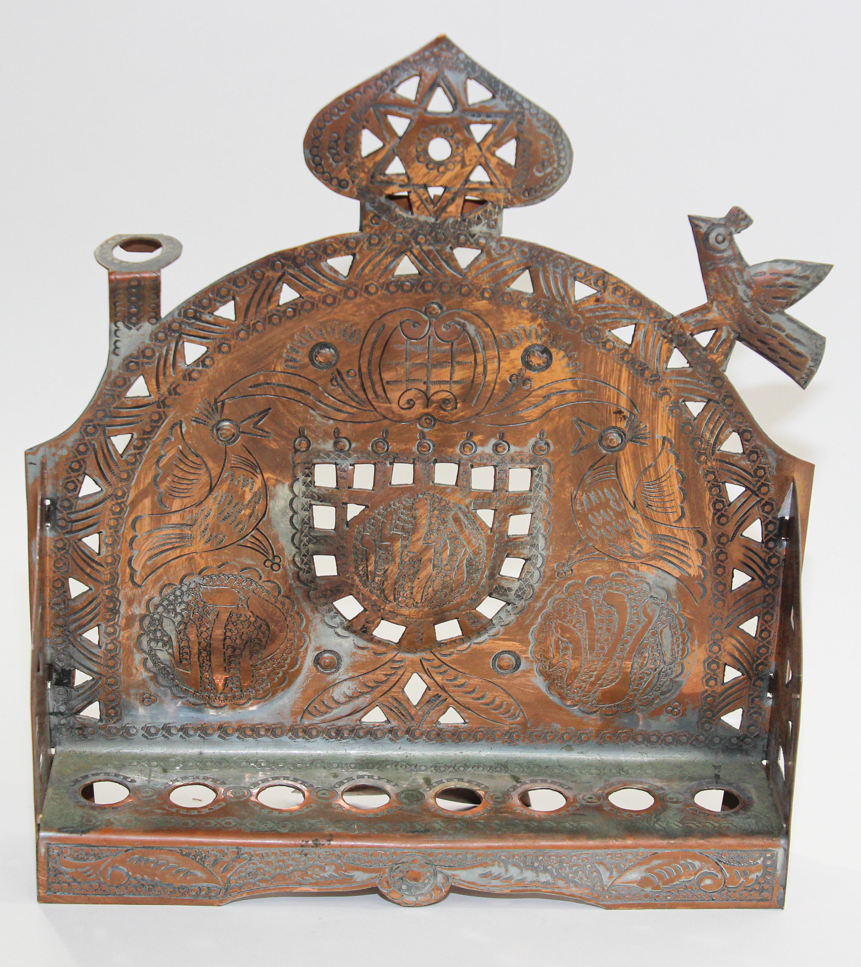 Menorah marocaine en cuivre pour Hanoukka.
Menorah Judaïque ou lampe de Hanoukka en laiton avec motif ajouré.
Menorah Judaïque ou lampe de Hanoukka en cuivre métal laiton avec motif décoratif ajouré et bougeoirs Shamash sur les deux côtés. Cuivre