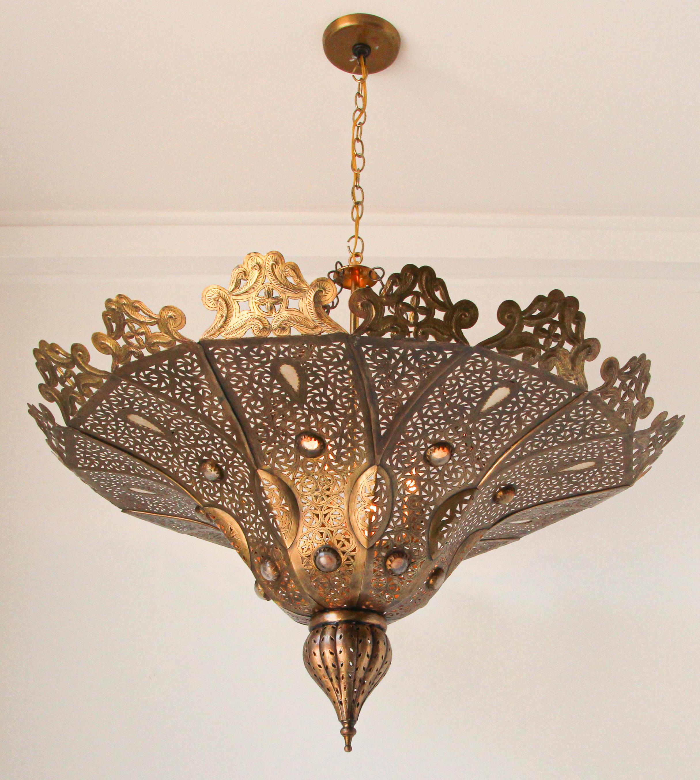 Handcrafted Moroccan brass Pasha chandelier.
This Pasha Moroccan chandelier is handmade of brass with inlay hand blown decorative milky glass.
Delicately handcrafted, hand-chase, hand-hammered and carved, the brass become a work of art.
Size: 33