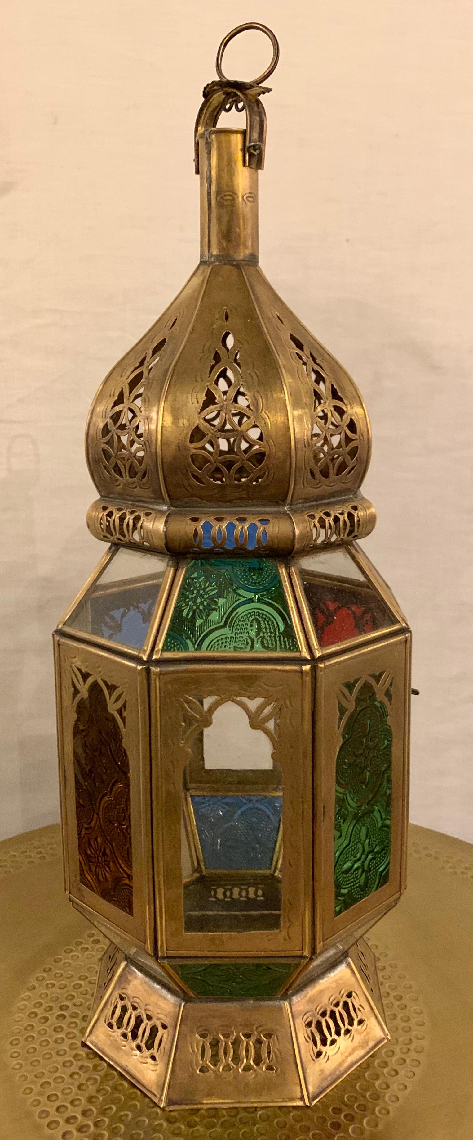An elegant pair of handmade gold brass table or hanging lanterns, candle or tea light holder. Beautifully carved in a Moorish style and decorated with multi-color glass in red, green and blue, the lanterns will create the boho chic and relaxing vibe