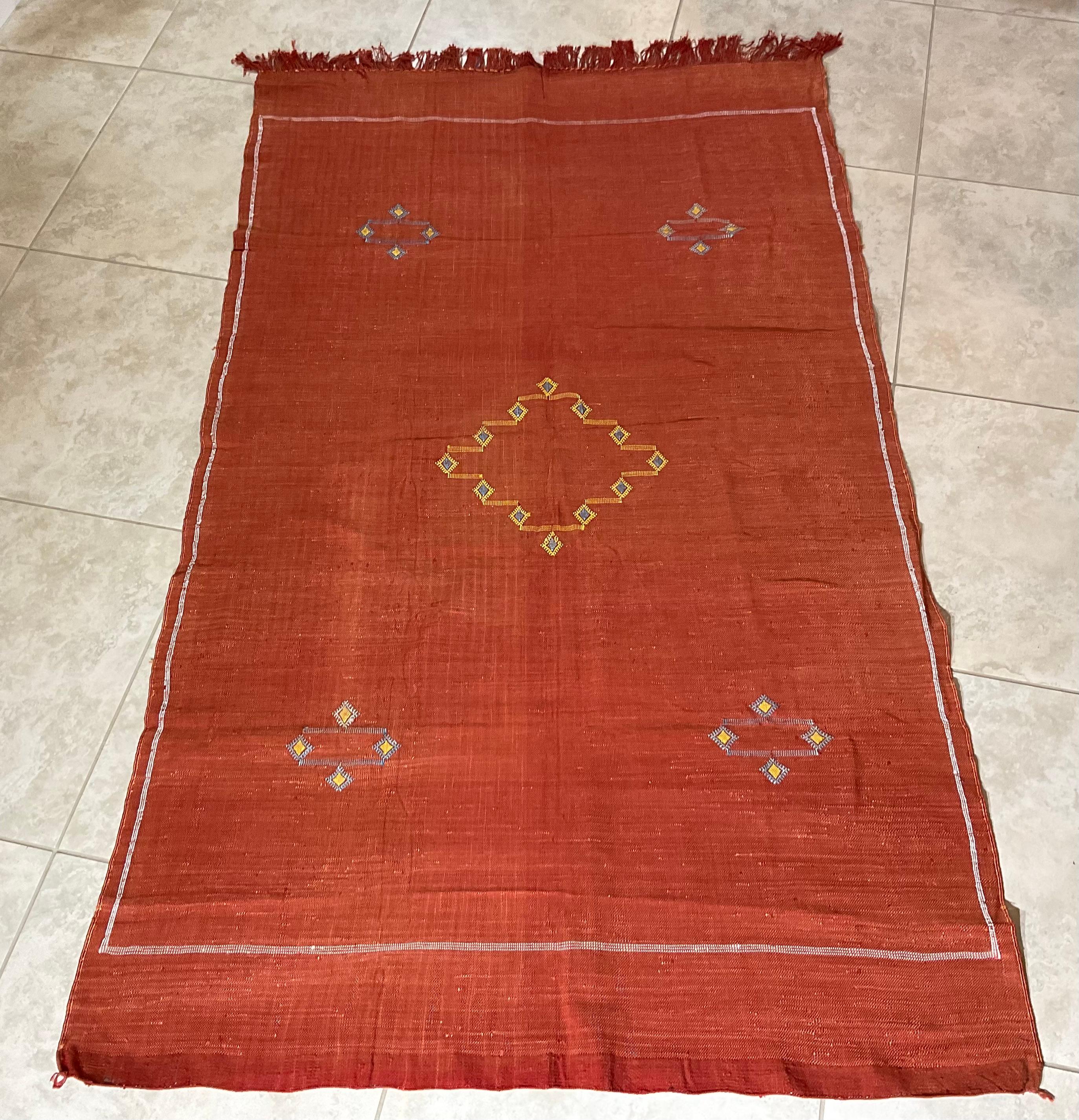 Wunderschöner handgewebter Teppich aus Kaktusseide mit weichen mehrfarbigen geometrischen Motiven auf einem lachsroten Hintergrund, der sich angenehm anfühlt. Eine tolle dekorative Ergänzung für jeden Raum.