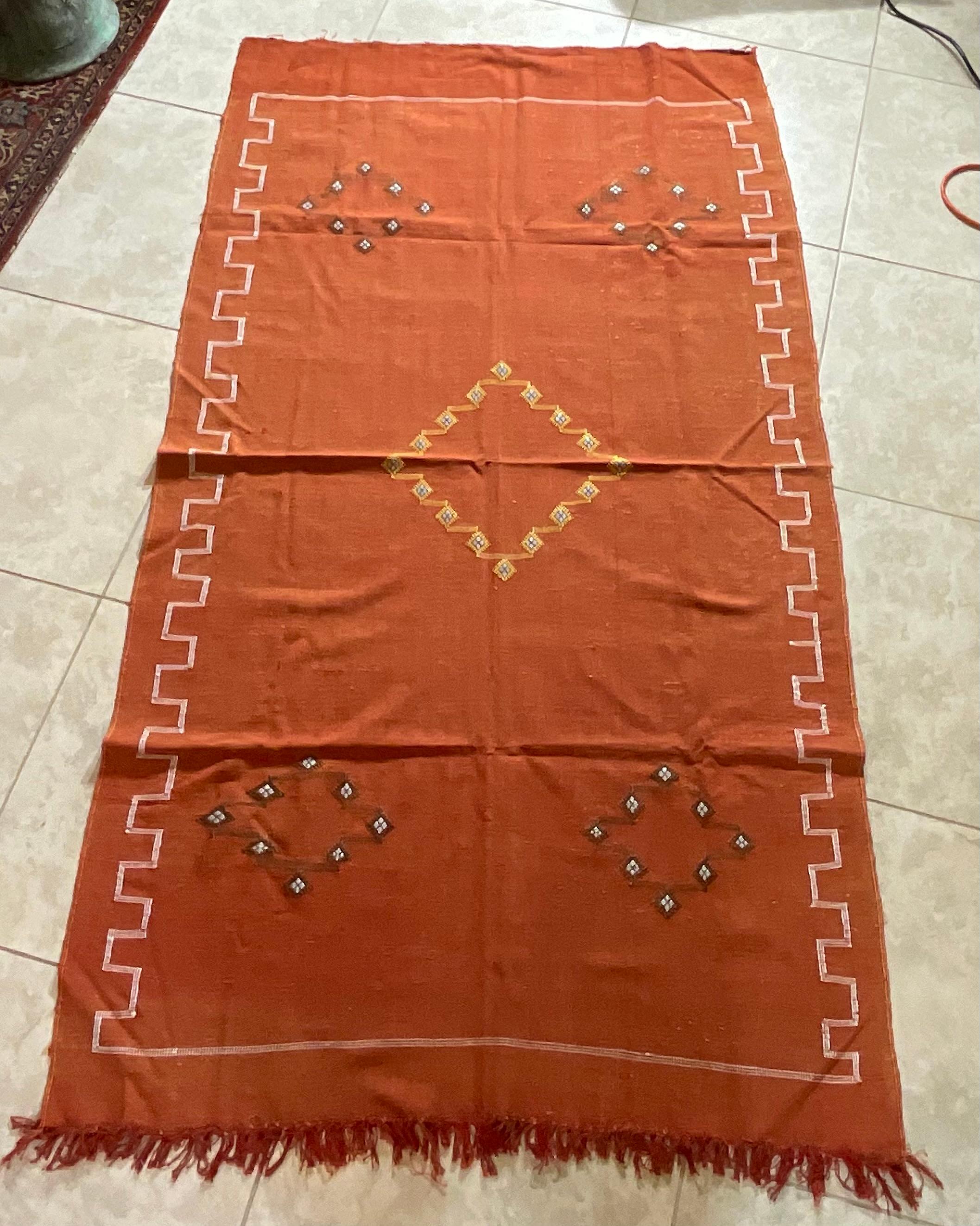 Beautiful handwoven rug made of cactus silk with soft multi-color geometric motifs on a red - salmon color background, nicely feel to touch. Great decorative addition for any room.