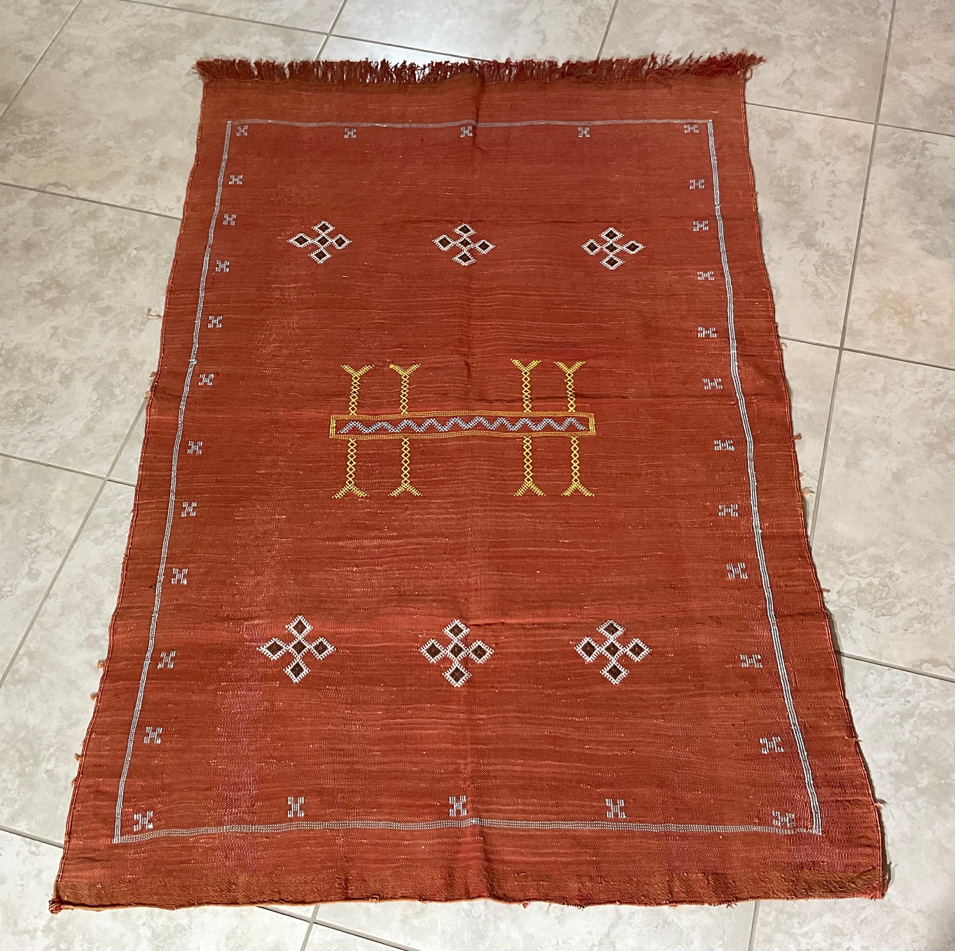 Wunderschöner handgewebter Teppich aus Kaktusseide mit weichen mehrfarbigen geometrischen Motiven auf einem lachsroten Hintergrund, der sich angenehm anfühlt. Eine tolle dekorative Ergänzung für jeden Raum.