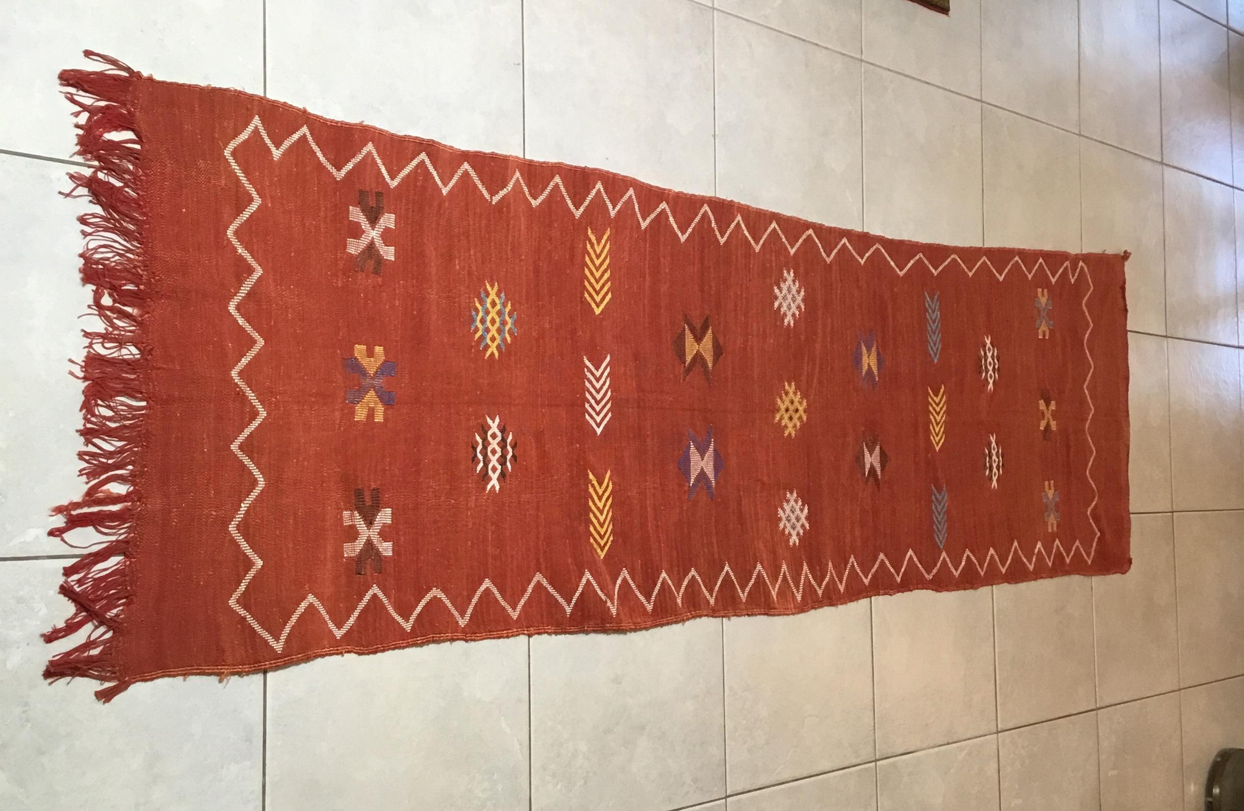 Beautiful handwoven rug made of cactus silk with soft multi-color geometric motifs on a red - salmon color background, nicely feel to touch. Great decorative addition for any room.