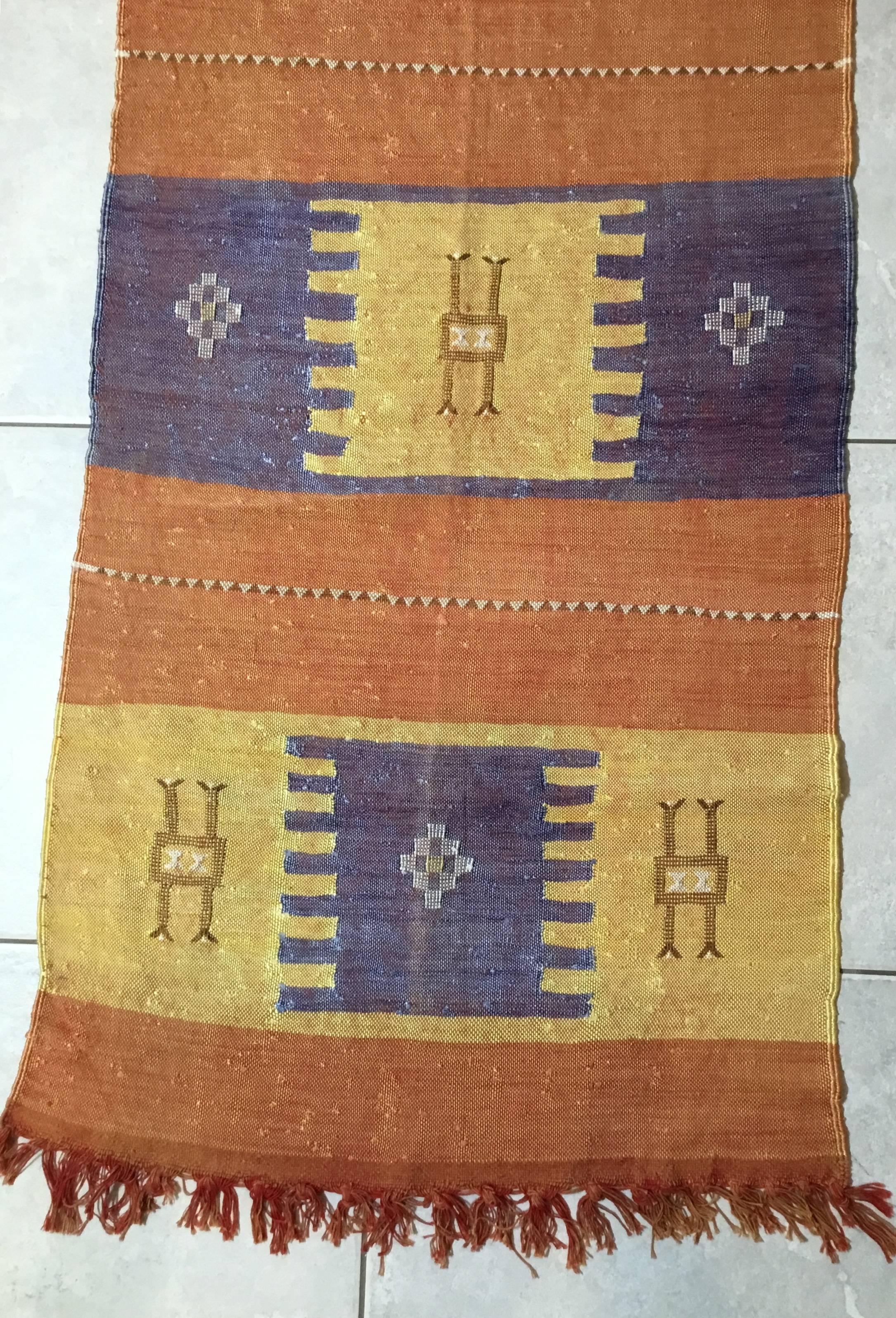 Beautiful decorative hand woven rug with repeated geometric motif
with soft colors of salmon, muster and purple. Nice feel to touch.