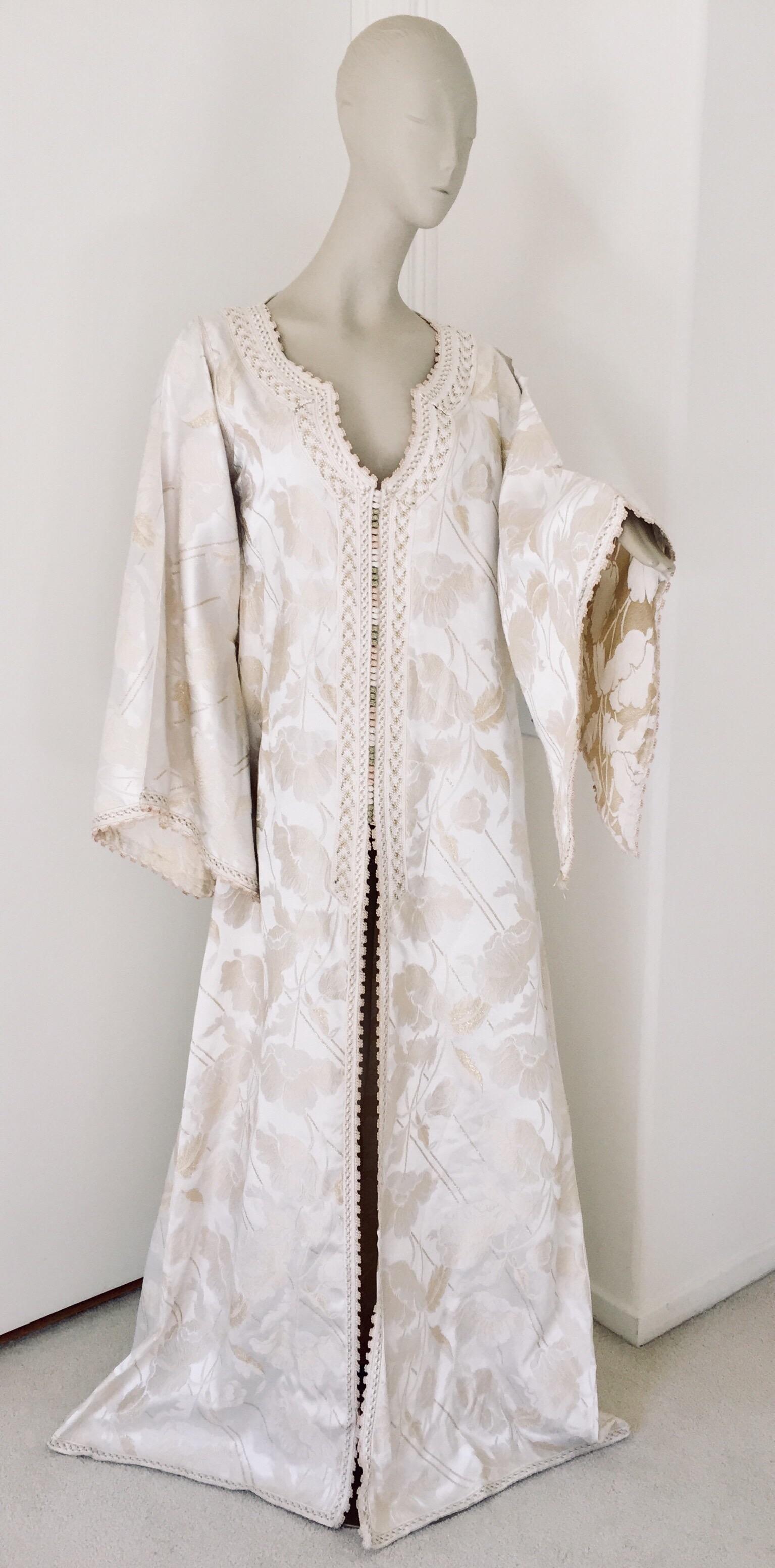 Elegant Moroccan white ivory and old brocade kaftan embroidered with gold trim threads.
Size L to XL circa 1980s.
This long maxi dress kaftan is embroidered and embellished entirely by hand.
One of a kind evening Moroccan Middle Eastern gown.
The