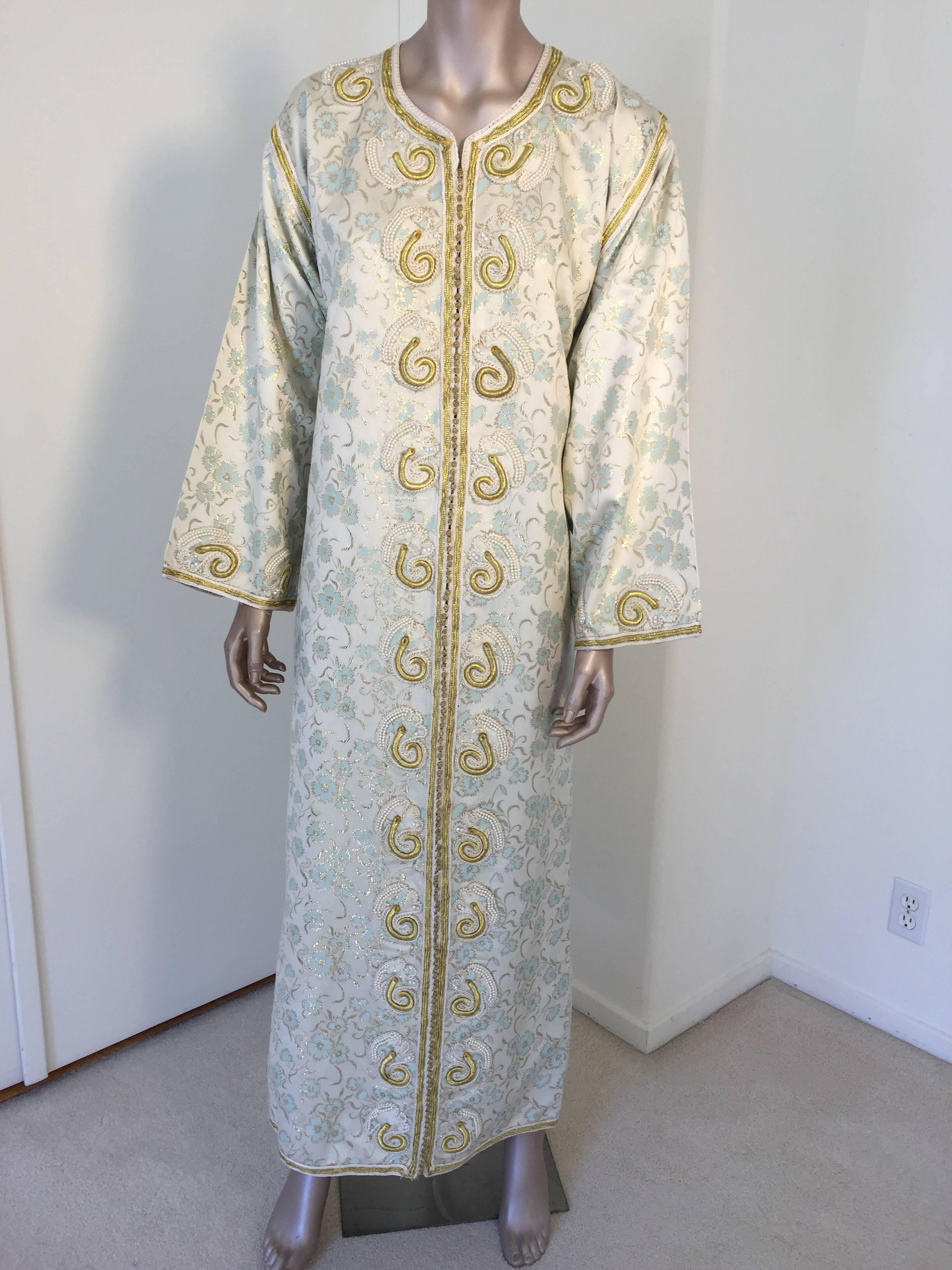 Elegant vintage designer Moroccan white brocade kaftan, embroidered with Turkish gold threads design. 
This chic Bohemian white, gold and light turquoise blue floral brocade maxi dress kaftan is embroidered and embellished with gold thread metallic