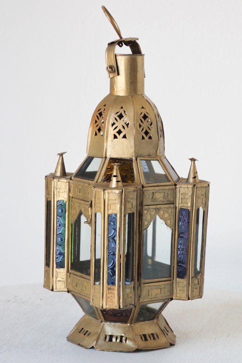 Piccola lanterna marocchina in metallo dorato o ciondolo moresco realizzato a mano.
Vetro stampato multicolore in verde, lavanda, blu e trasparente.
Lampada a candela Hurricane realizzata a mano a Marrakech, in metallo vintage con finitura