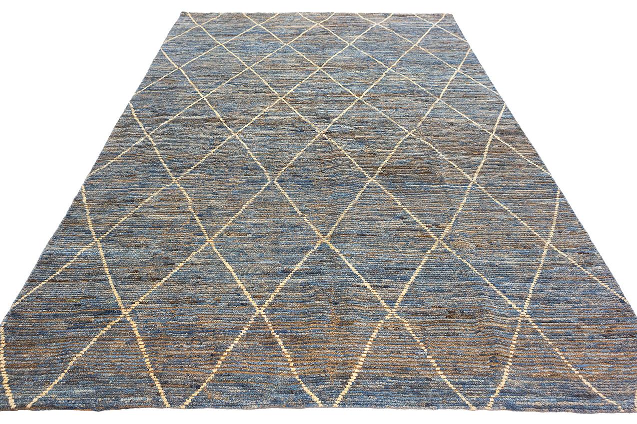 This is a Moroccan Carpet that embodies the essence of minimalism, hand-knotted and generously sized at 305 x 201 CM. This carpet is a remarkable fusion of simplicity and artistry, where less is indeed more. What distinguishes this Moroccan Carpet