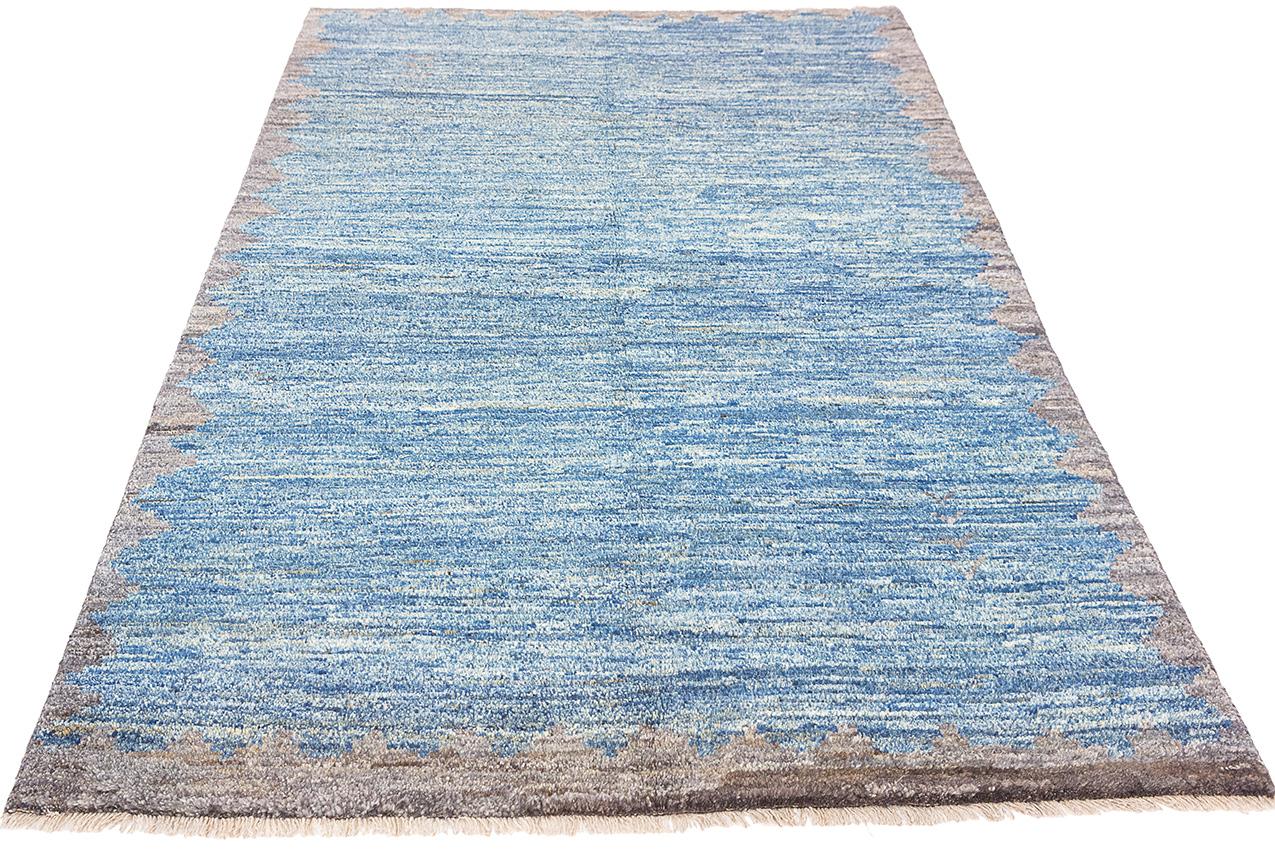 This is a Moroccan Carpet, a masterpiece of minimalism, adorned with a serene color palette of blues and grays. This carpet is more than a floor covering; it's a canvas of tranquility that seamlessly blends modern elegance with Moroccan artistry.