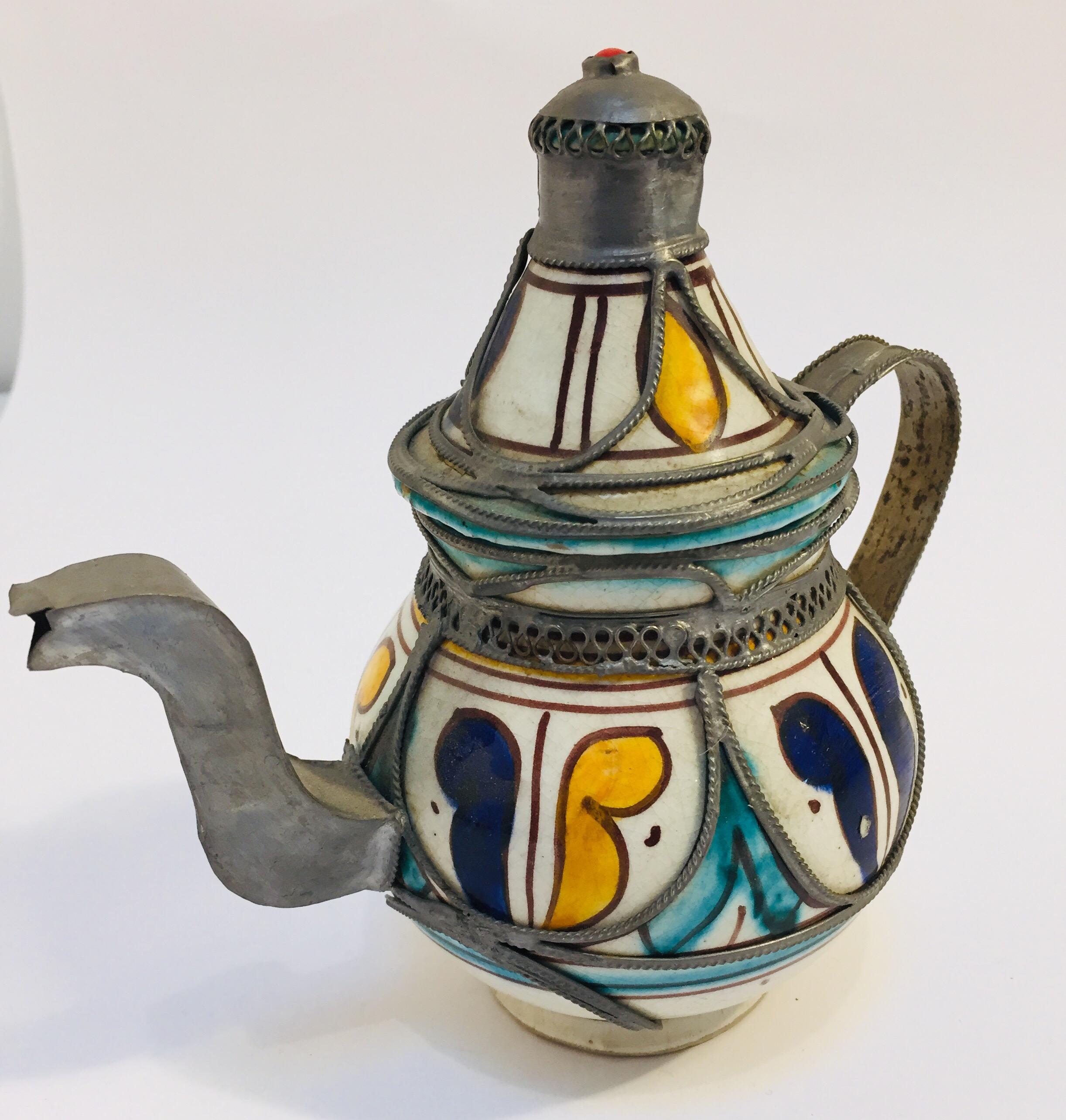 Traditional vintage ceramic and silver metal filigree Moroccan tea pot.
Decorative tea pot with traditional hand painted design in yellow, white and blue, handcrafted in Fez, stamped in bottom.
Great decorative Moroccan ceramic art object.
Will
