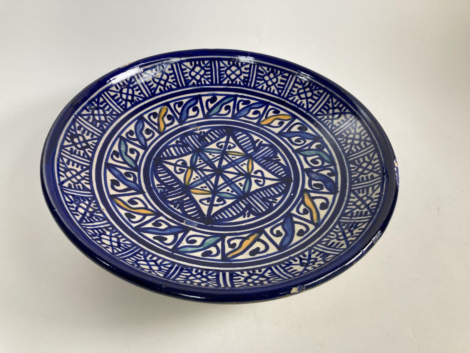 Early 20th century blue Moroccan Ceramic plate hand made in Fez.
Handcrafted and glazed decorative ceramic bowl from Fez, Morocco.
Featuring an elaborate hand-painted Moorish pattern in blue and white with some yellow accents.
One-of-a-kind antique