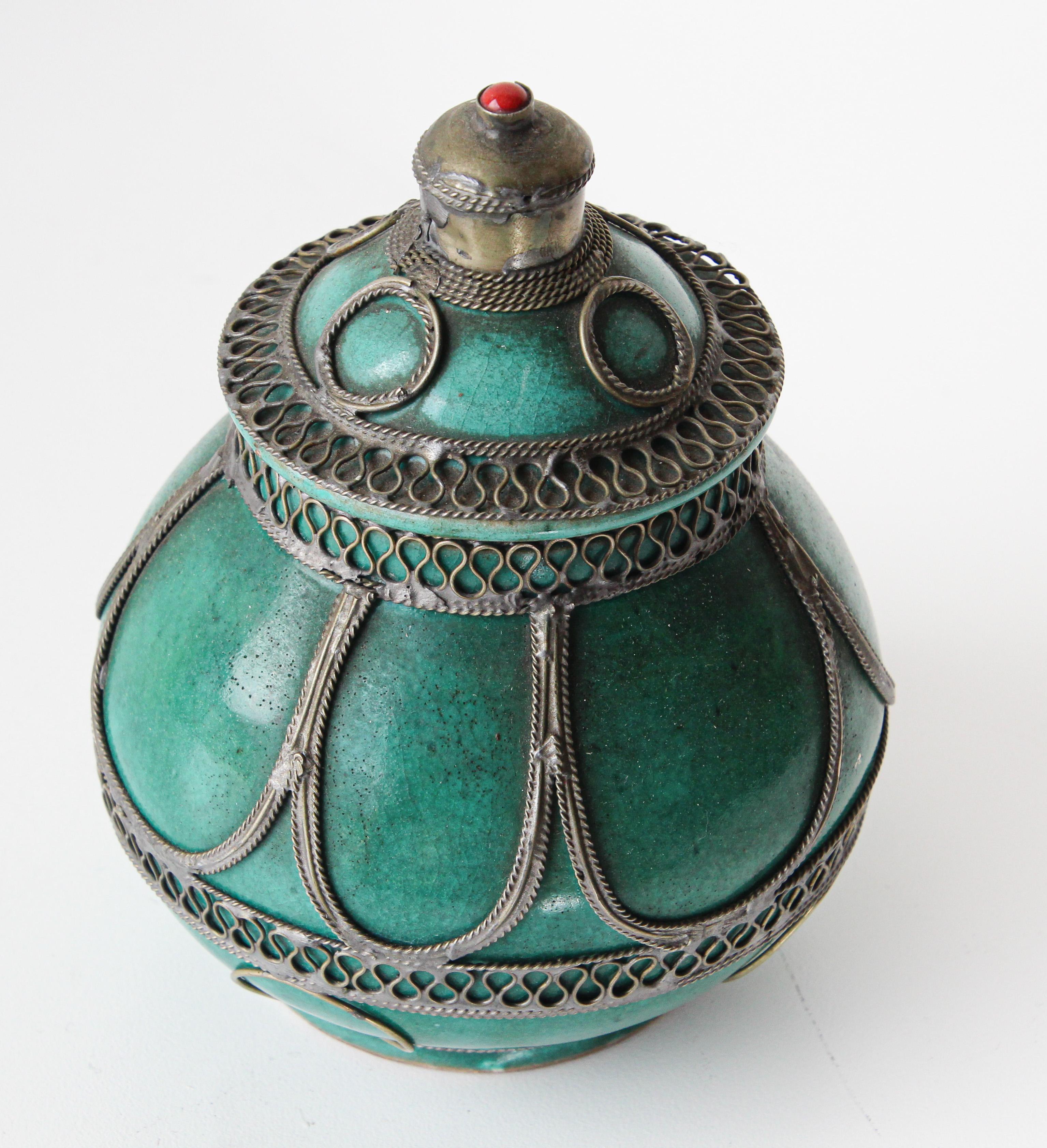 Handcrafted antique Moroccan ceramic lidded urn in Moorish style adorned with fine filigree silver nickel work overlaid.
Emerald green ceramic box with lid with silver filigree.
Dimensions: 8