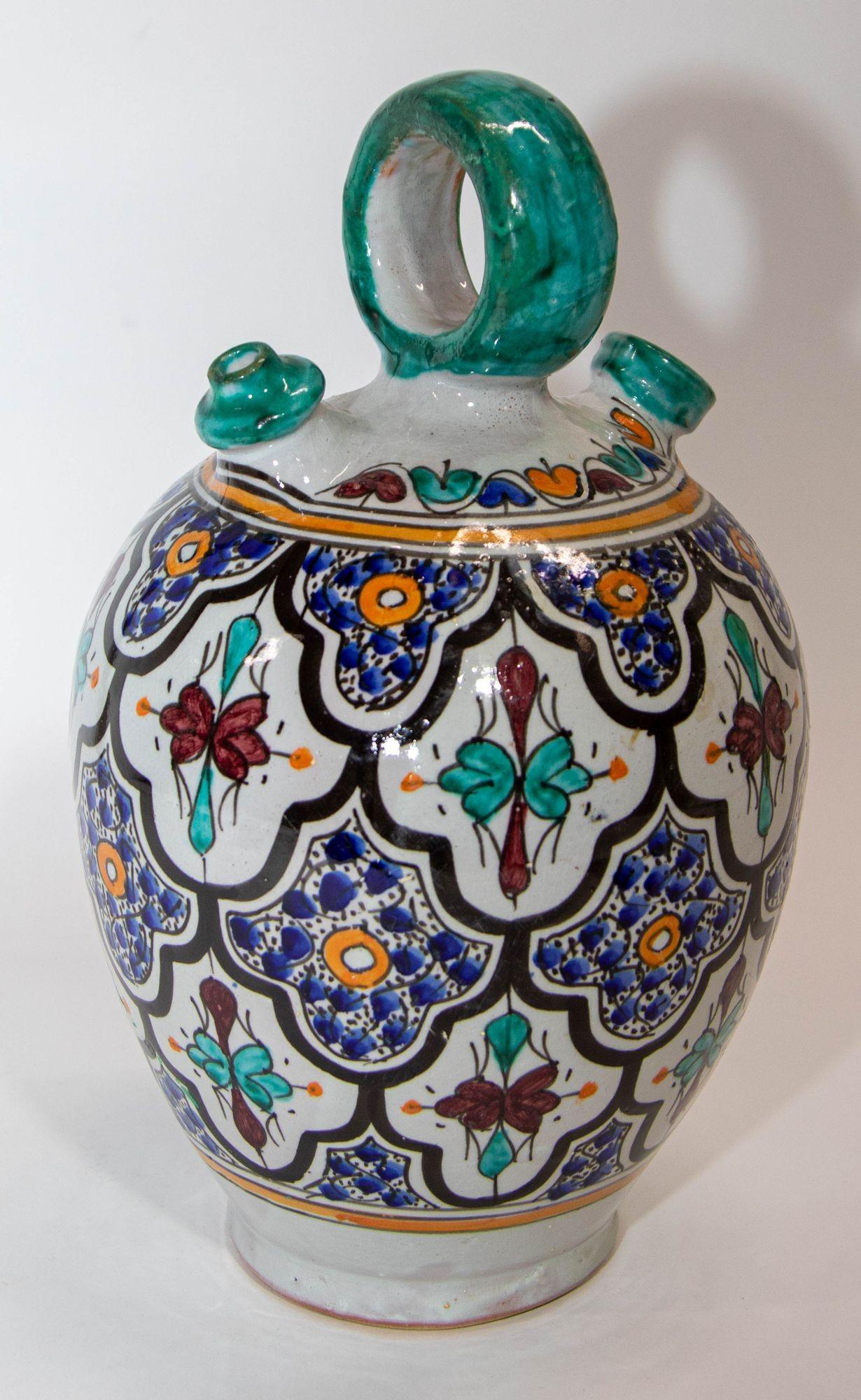 Verseuse en céramique polychrome émaillée marocaine avec anse.
Vase en céramique peint à la main, fabriqué par des artisans marocains qualifiés à Fès, au Maroc.
Peint à la main en motifs mauresques de Grenade dans des couleurs turquoise, bleu