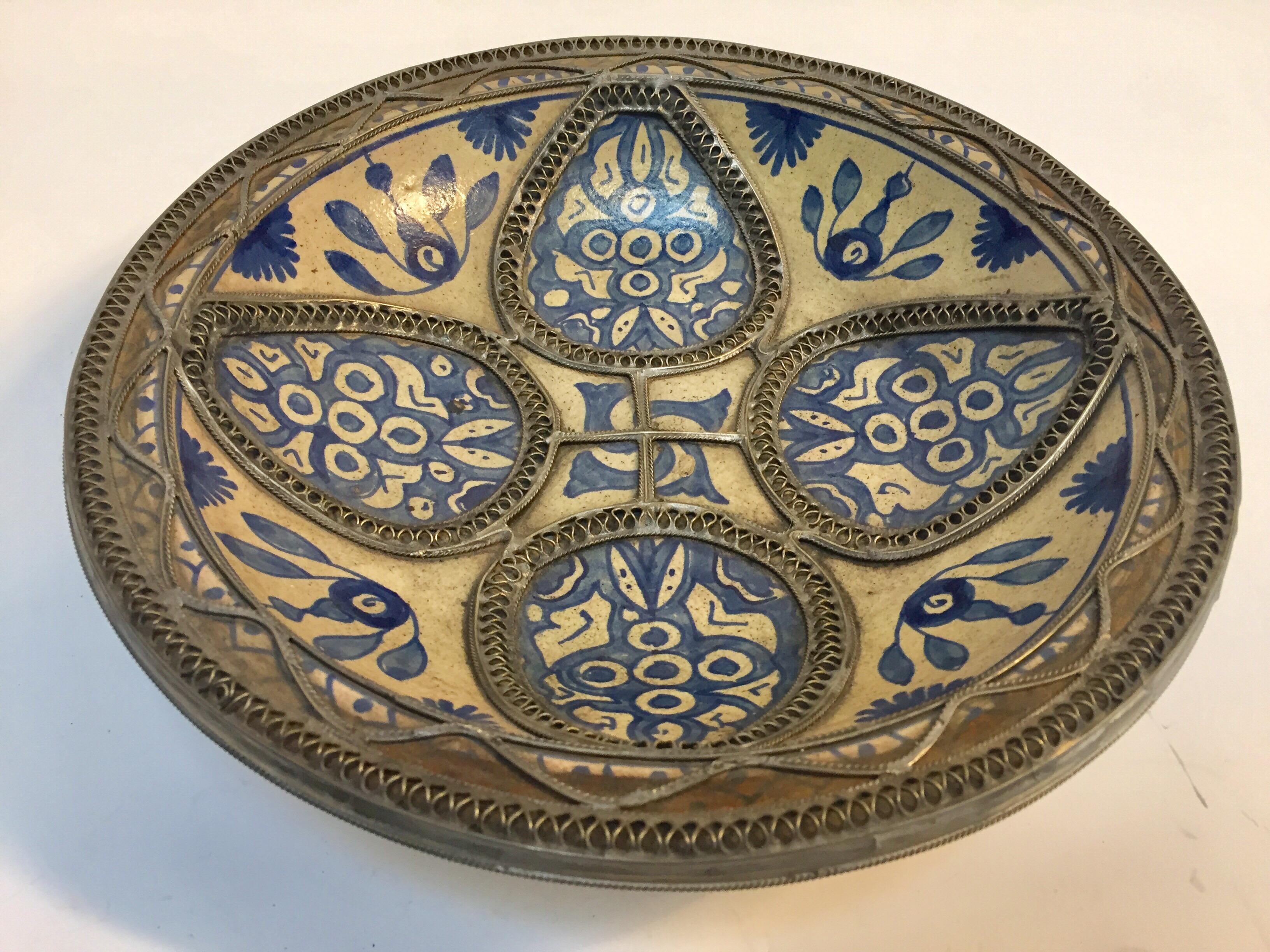 Handcrafted large Moroccan polychrome decorative ceramic plate from Fez. Bleu de Fez, very nice designs hand-painted by artist in Fez.
Geometrical and floral designs and adorned with nickel silver filigree designs.