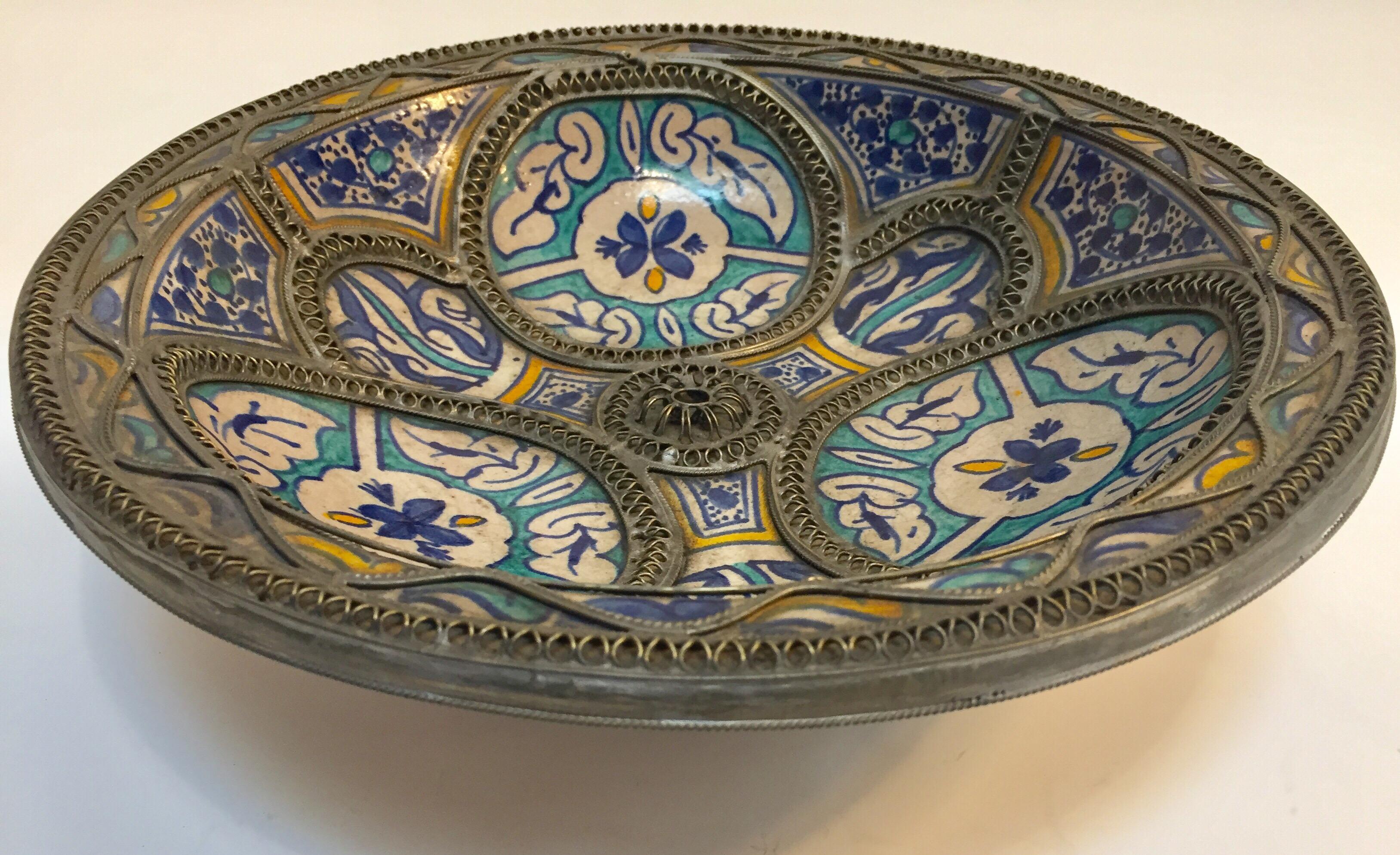 Handcrafted large Moroccan polychrome decorative ceramic plate from Fez. Bleu de Fez, very nice designs hand painted by artist in Fez.
Geometrical and floral designs and adorned with nickel silver filigree designs.