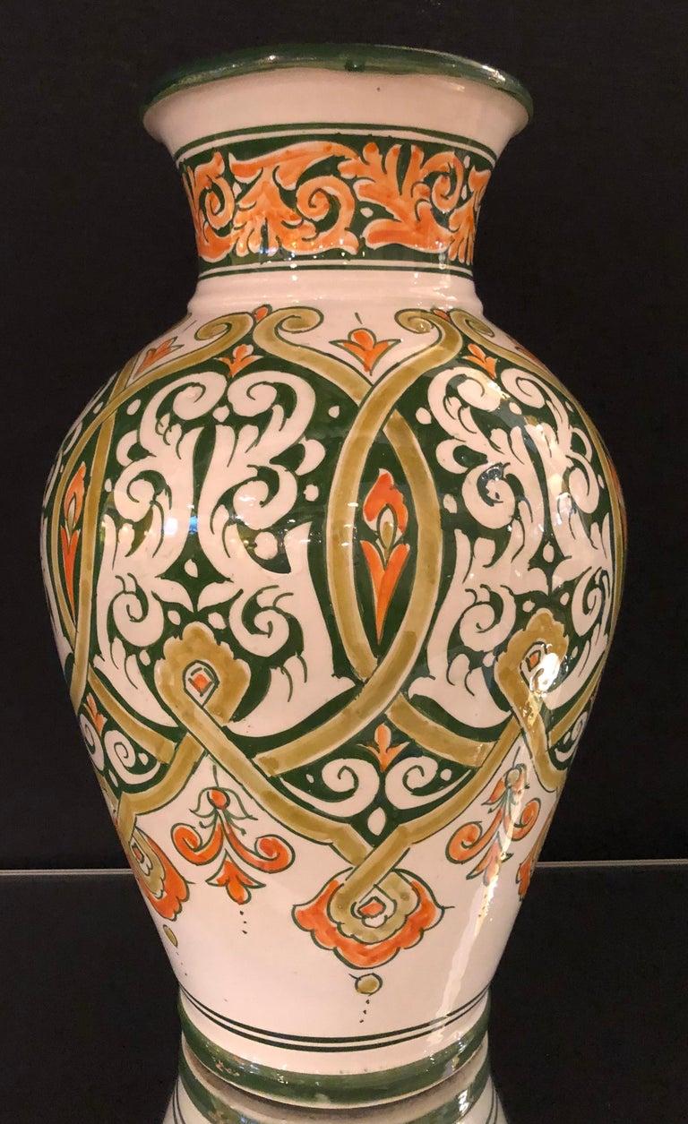 Featuring cool, serene shades of green and orange and an exquisite hand painted arabesque design, this sumptuous handcrafted ceramic vase provides a breezy elegance to any living space. This piece is part of an extensive collection of Moroccan home