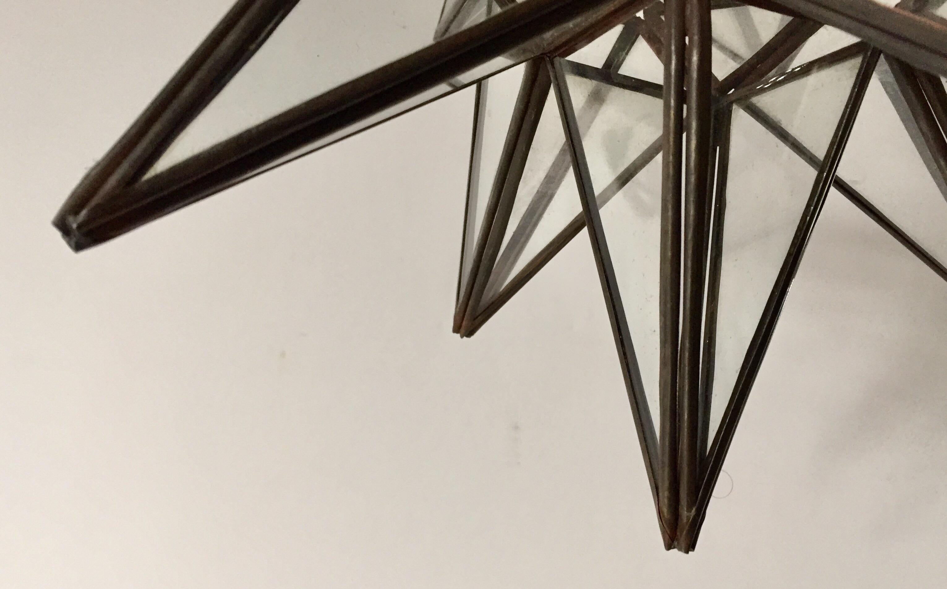 Moroccan clear glass and metal framed Moravian star shape lantern A beautiful vintage geometric metal and glass star pendant. Multifaceted large star lantern with glass panels that form geometrical shapes similar to Moravian stars. The lantern has