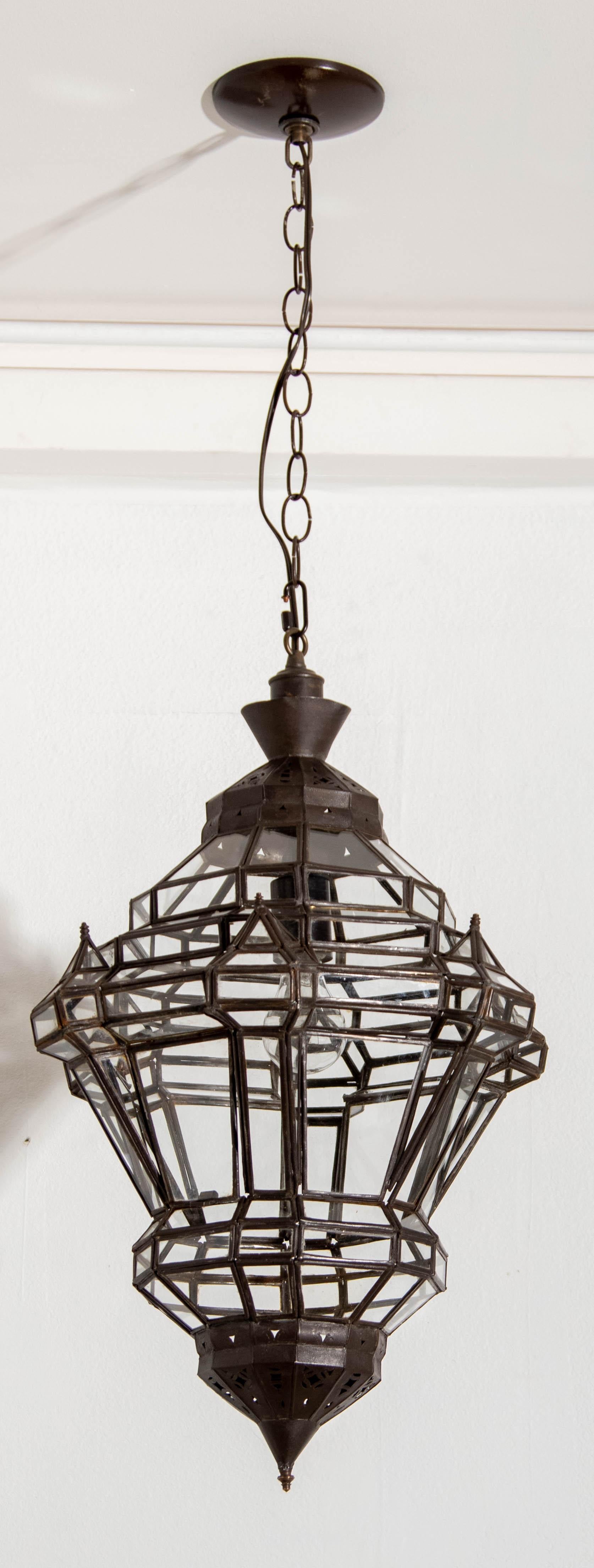 Farol vintage marroquí de cristal transparente estilo morisco granadino español.
Versión más pequeña de nuestro elegante colgante marroquí Granada, farolillo marroquí de cristal transparente en forma de diamante con acabado metálico en bronce.
Este