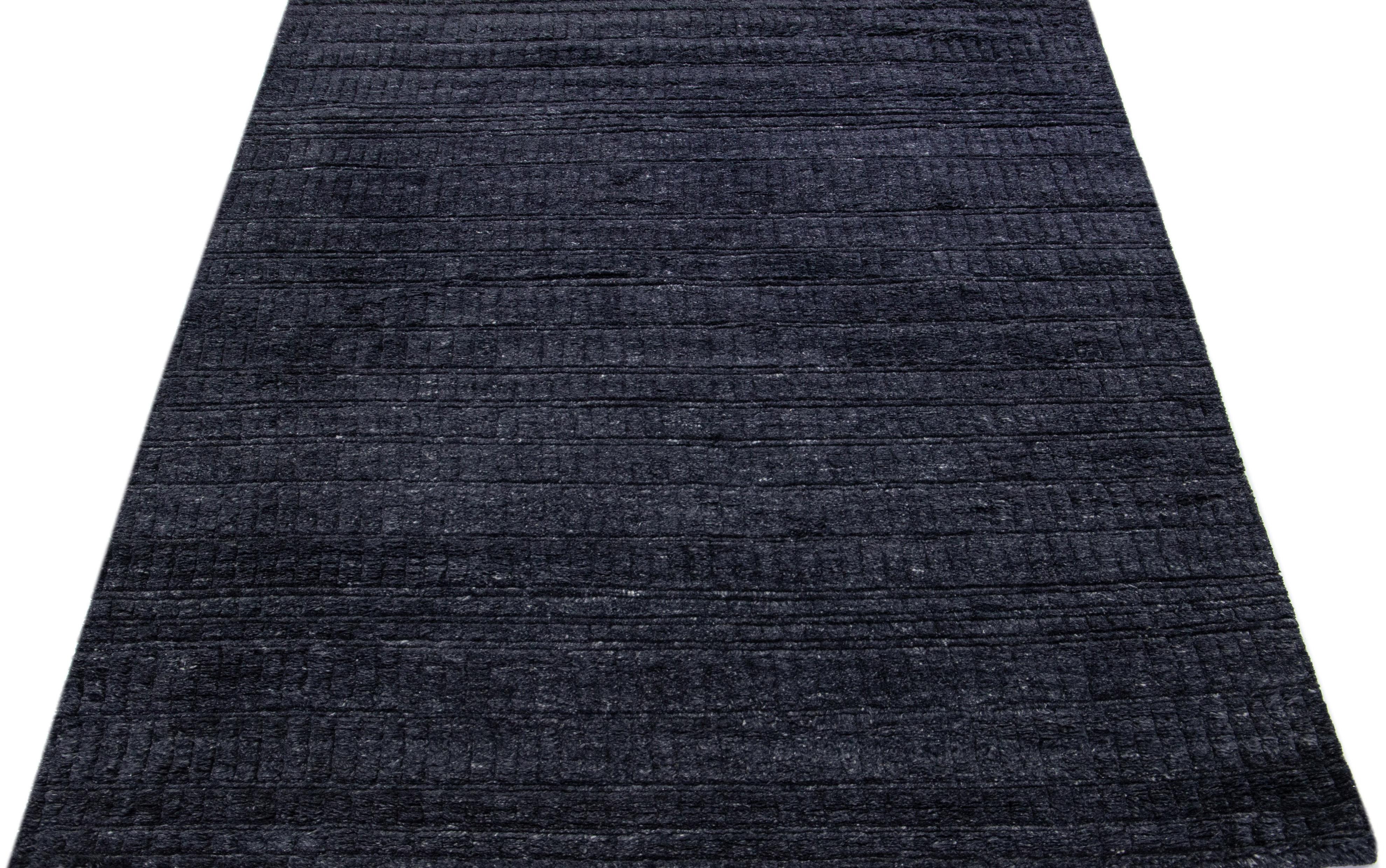 Beautiful Contemporary Moroccan Texture Home Collection rugs. This Indian hand-knotted rug is made of wool and has a gray-charcoal color field in a minimalist design. 

This rug measures: 7'7