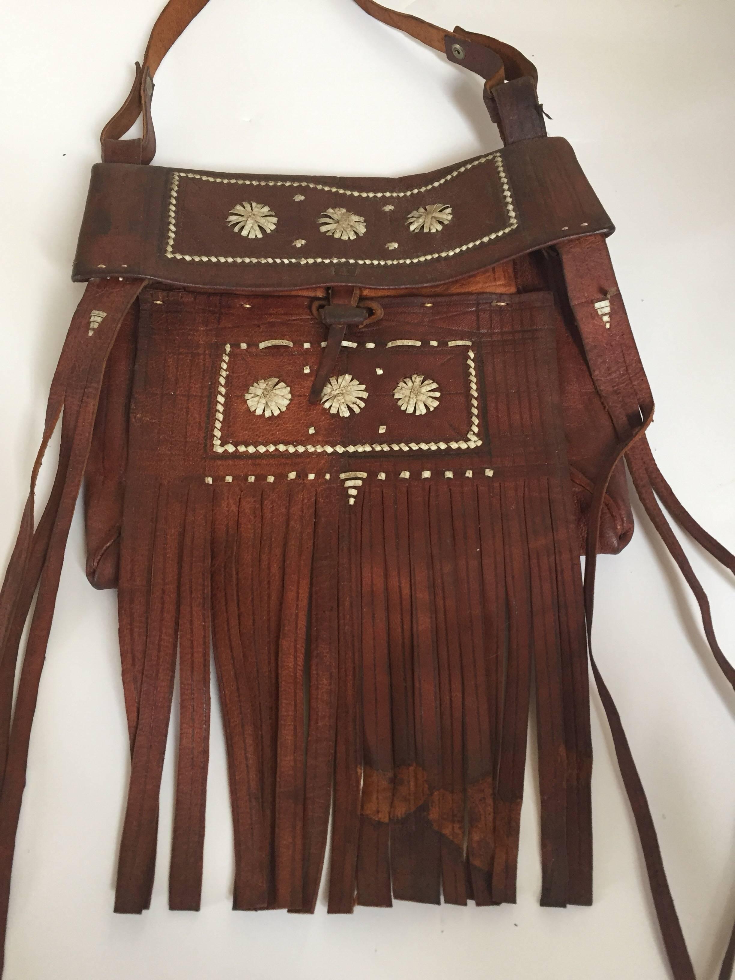 Vintage 1970er Jahre afrikanischen marokkanischen Leder handgefertigt Tuareg Tasche mit Fransen.
Authentisches Kunstwerk, das von den Berberstämmen Marokkos handgefertigt wurde.
Eng gewebte bunte Lederstreifen bilden ein kompliziertes geometrisches