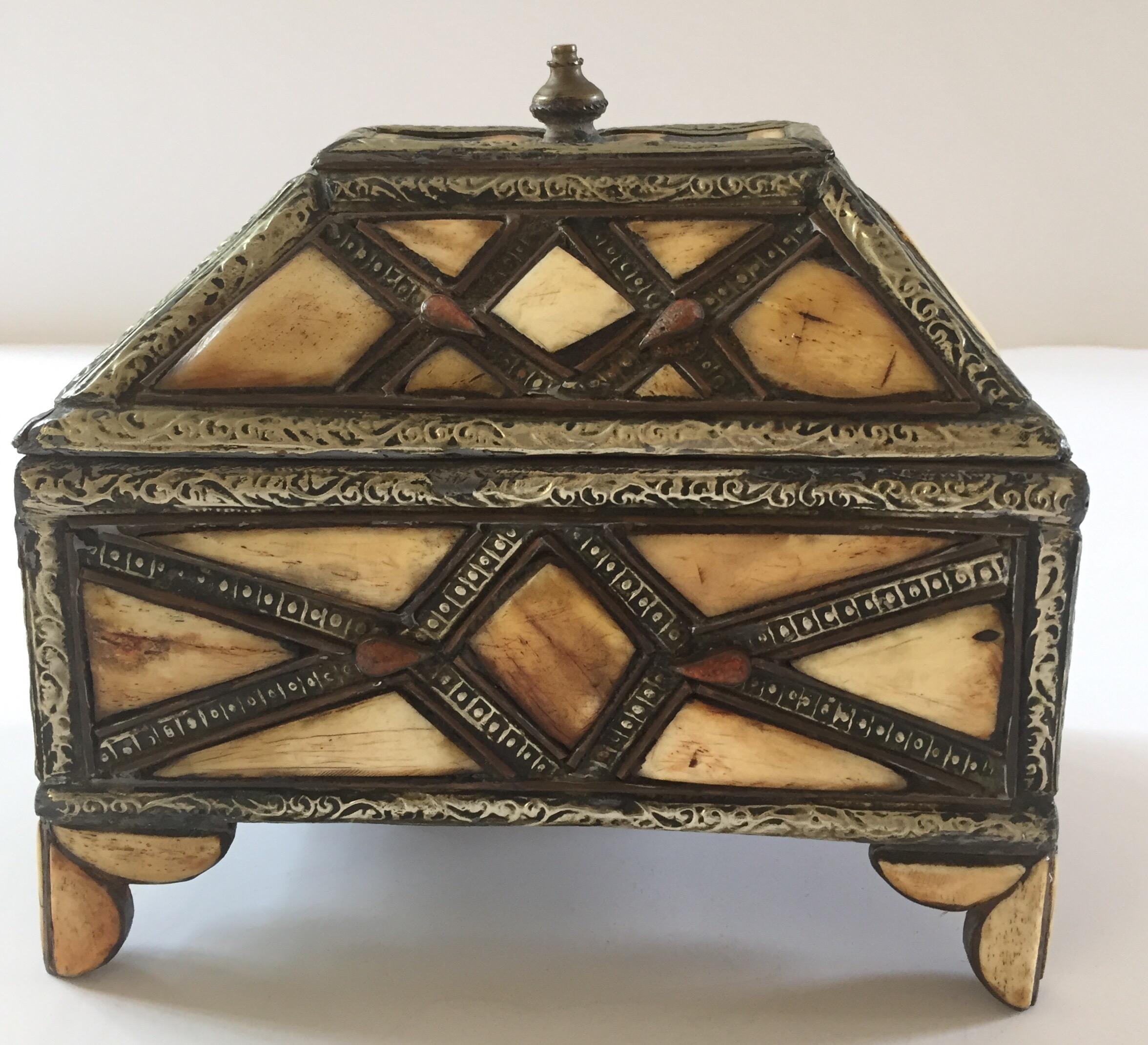 Moroccan decorative footed jewelry box inlaid with camel bone and brass.
Moroccan Moorish jewelry box hand-carved all-over with silvered brass and camel bone inlaid.
Leather lined inside.
One of a kind Moroccan islamic art-work handcrafted in
