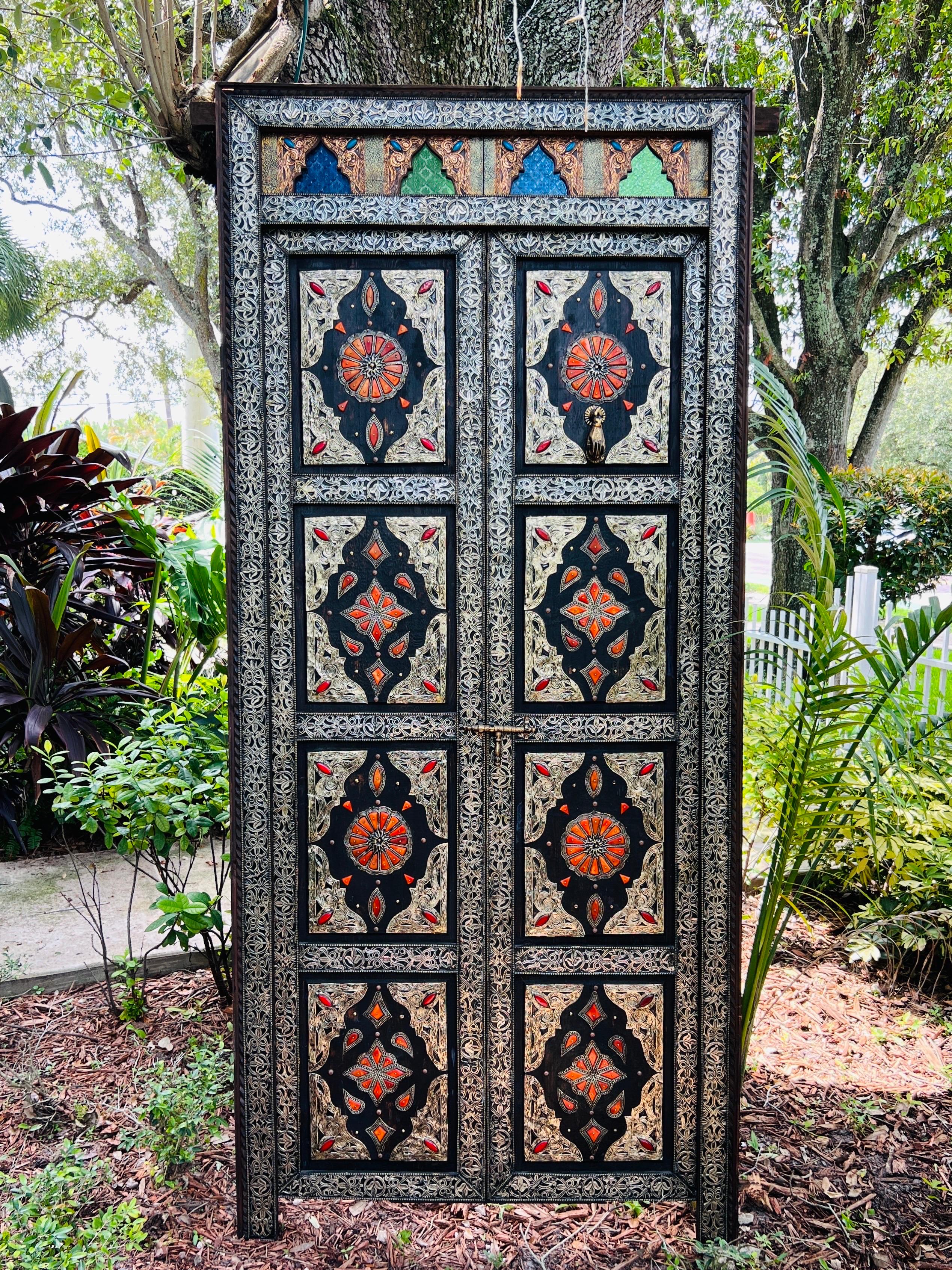 Spectacular Moroccan doorway with paneled double doors. One-of-a-kind palace craftsmanship featuring intricate and ornamented metal work with Moorish motifs on both sides of the doors.  The ebonized wood frame has silver metal overlays with