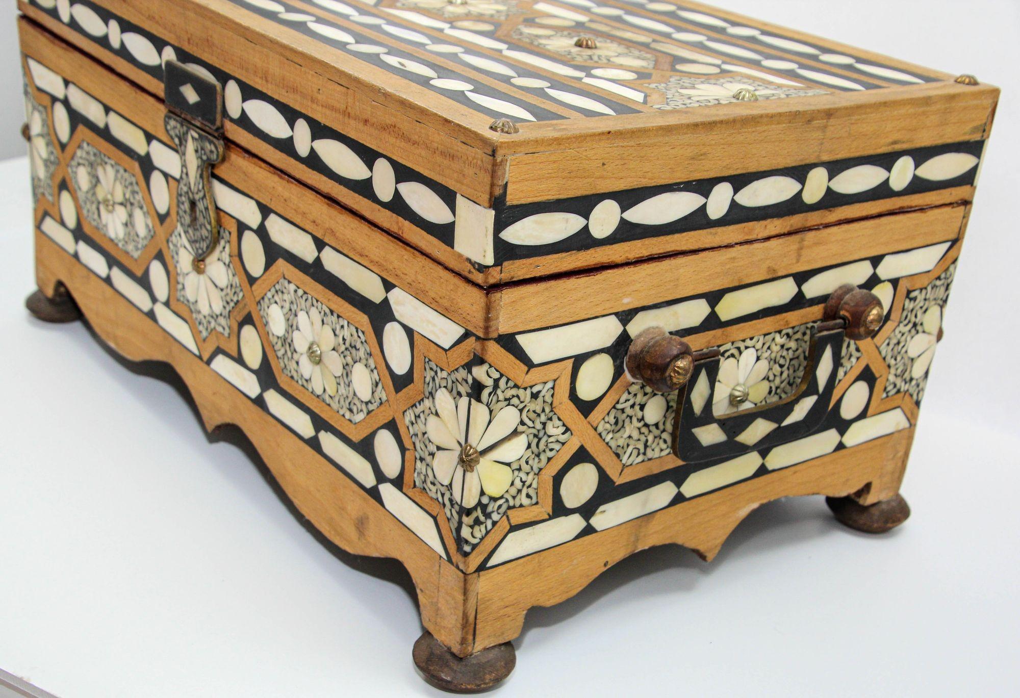 Antique handcrafted Moroccan jewelry wooden box with camel bone inlay trunk.
A large early 20th century decorative Moroccan camel bone casket with brass carrying handles on bun feet.
Magnificent large rectangular shape Moroccan dowry box decorated