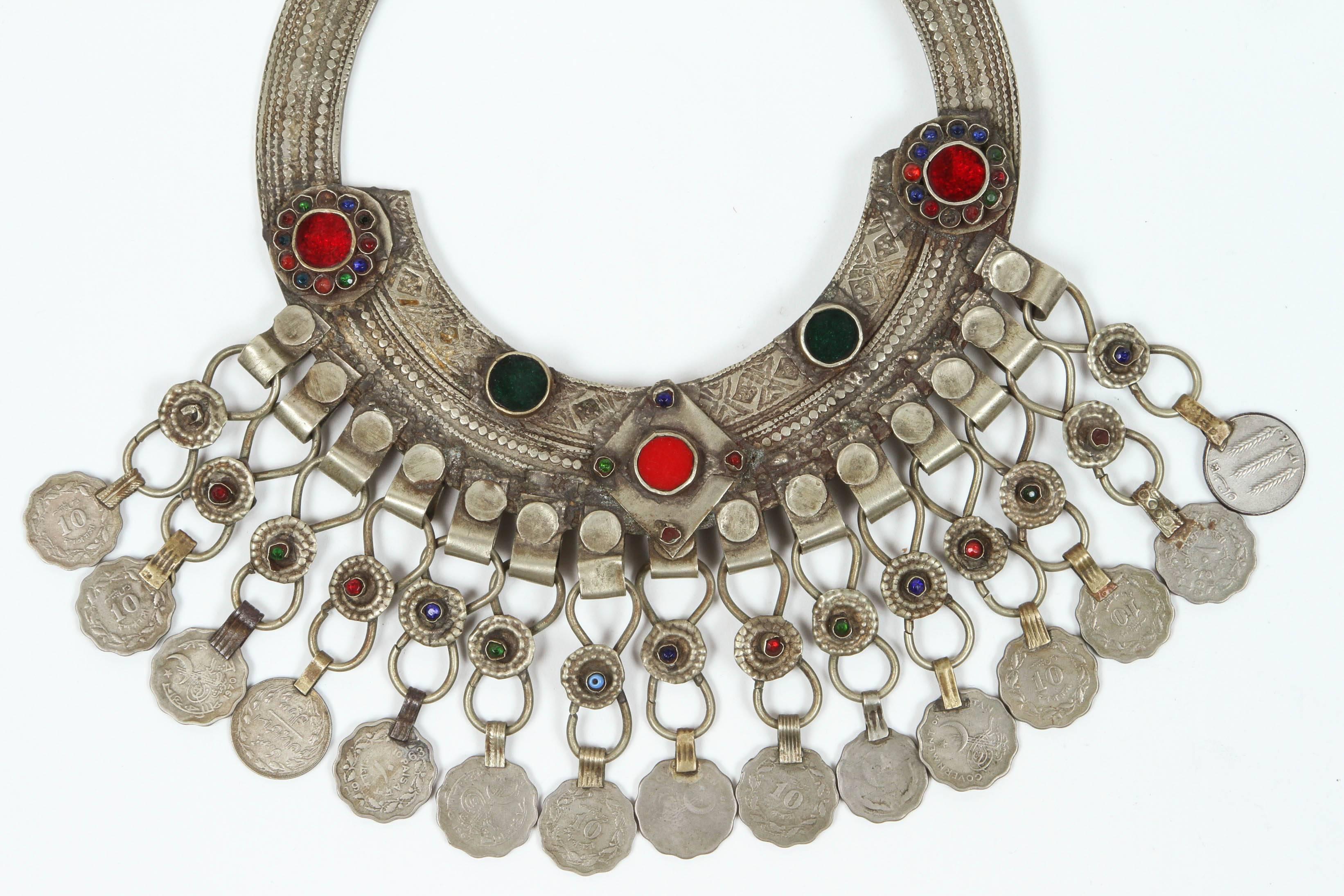 A Moroccan Tribal jewelry vintage a chocker inlaid with colorful glass beads in red and green and dangling coins. Silver, but not of the standard of sterling and richly embellished with applied silver designs and filigree. 
Chocker size: 10