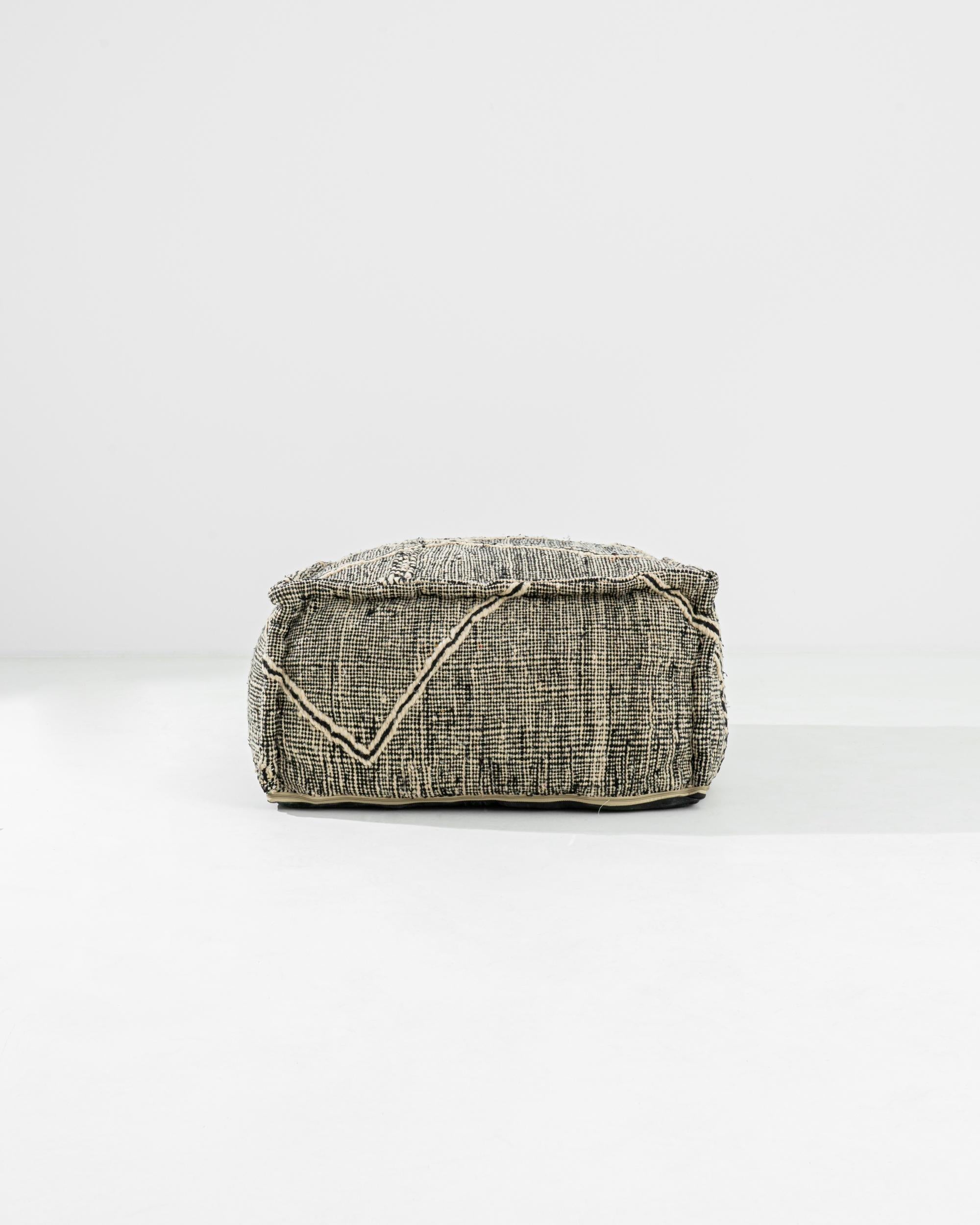 Bringen Sie einen Hauch von globalem Charme in Ihr Zuhause mit dem Zanafi Pouf aus marokkanischem Stoff in Schwarz und Weiß. Dieser wunderschöne Hocker ist aus hochwertigem Stoff handgefertigt und zeigt ein unverwechselbares Zanafi-Muster, das