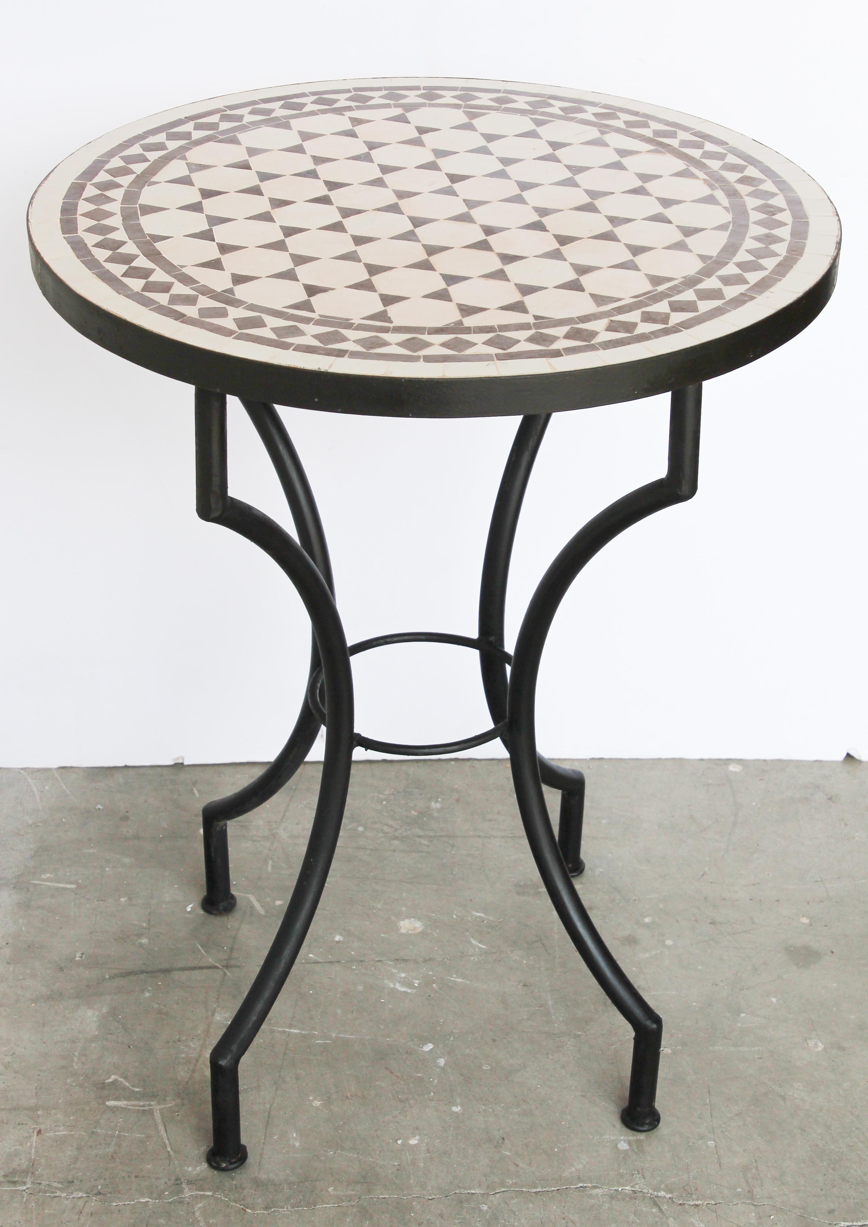 Moroccan mosaic tiles bistro table on iron base.
Handmade by expert artisans in Fez, Morocco using reclaimed old glazed brown and white colors tiles inlaid in concrete and making beautiful geometrical Moorish Fez designs, colors are brown and