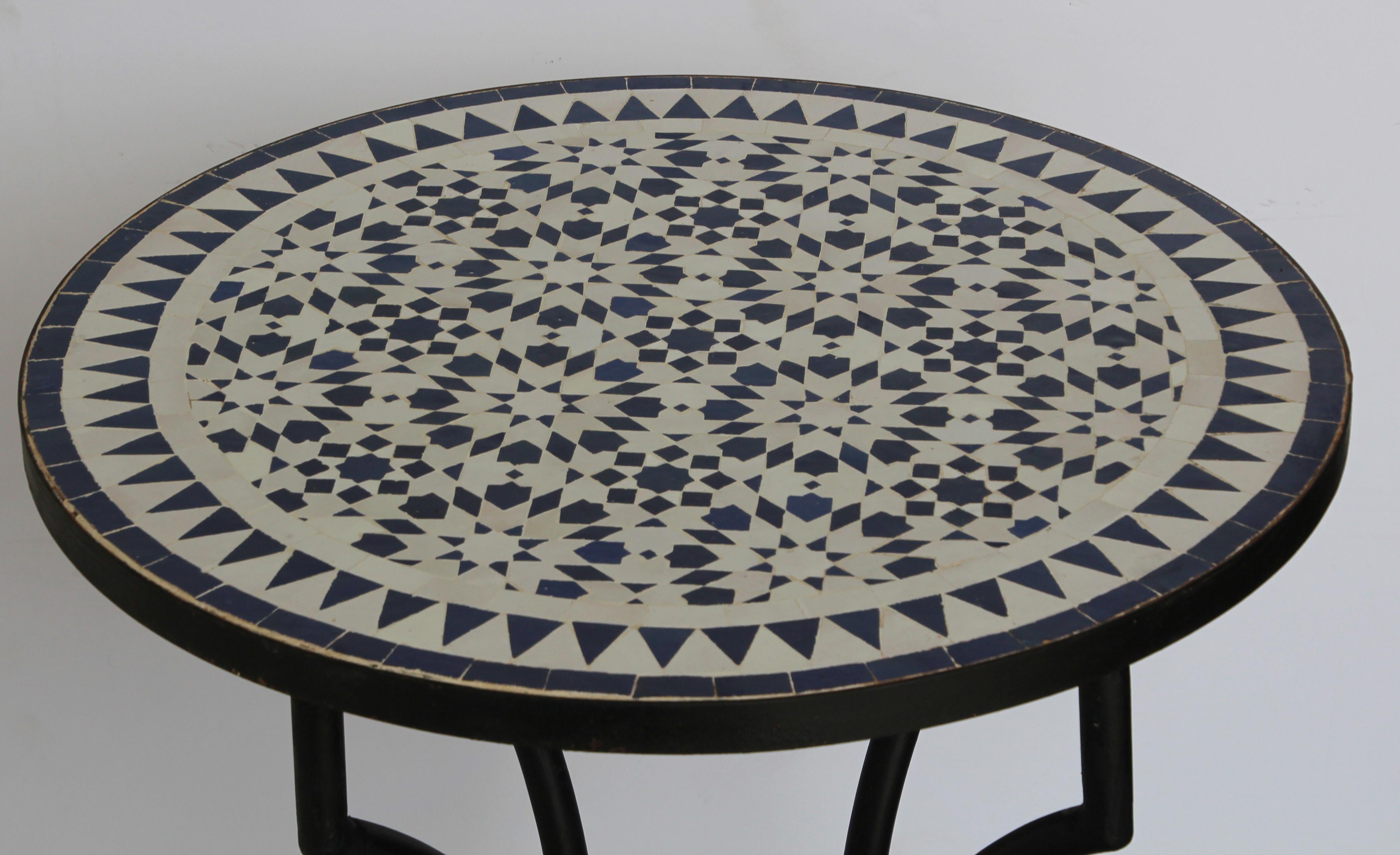 Moroccan mosaic tiles bistro table on iron base.
Handmade by expert artisans in Fez, Morocco using reclaimed old glazed blue and white colors tiles inlaid in concrete and making beautiful geometrical Moorish Fez designs, colors are blue and white,