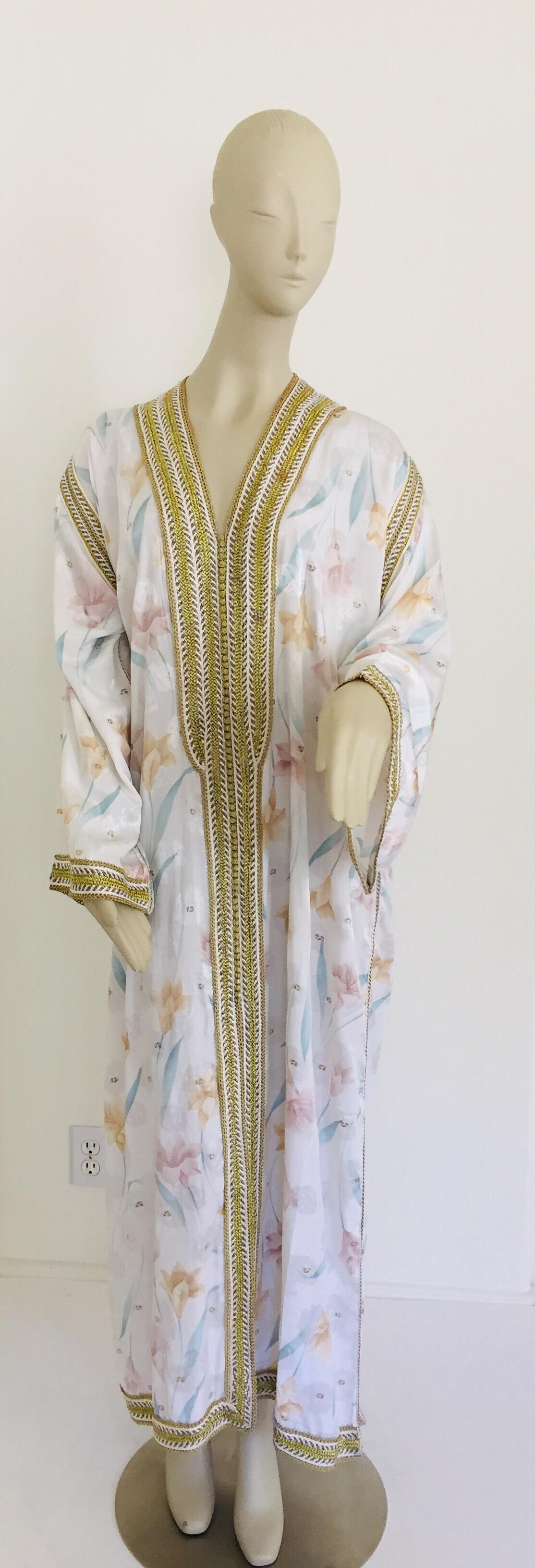Elegant Moroccan caftan white floral embroidered with gold trim,
circa 1970s.
This long maxi dress kaftan trim is embroidered and embellished entirely by hand.
One of a kind evening Moroccan Middle Eastern gown.
The kaftan features a traditional