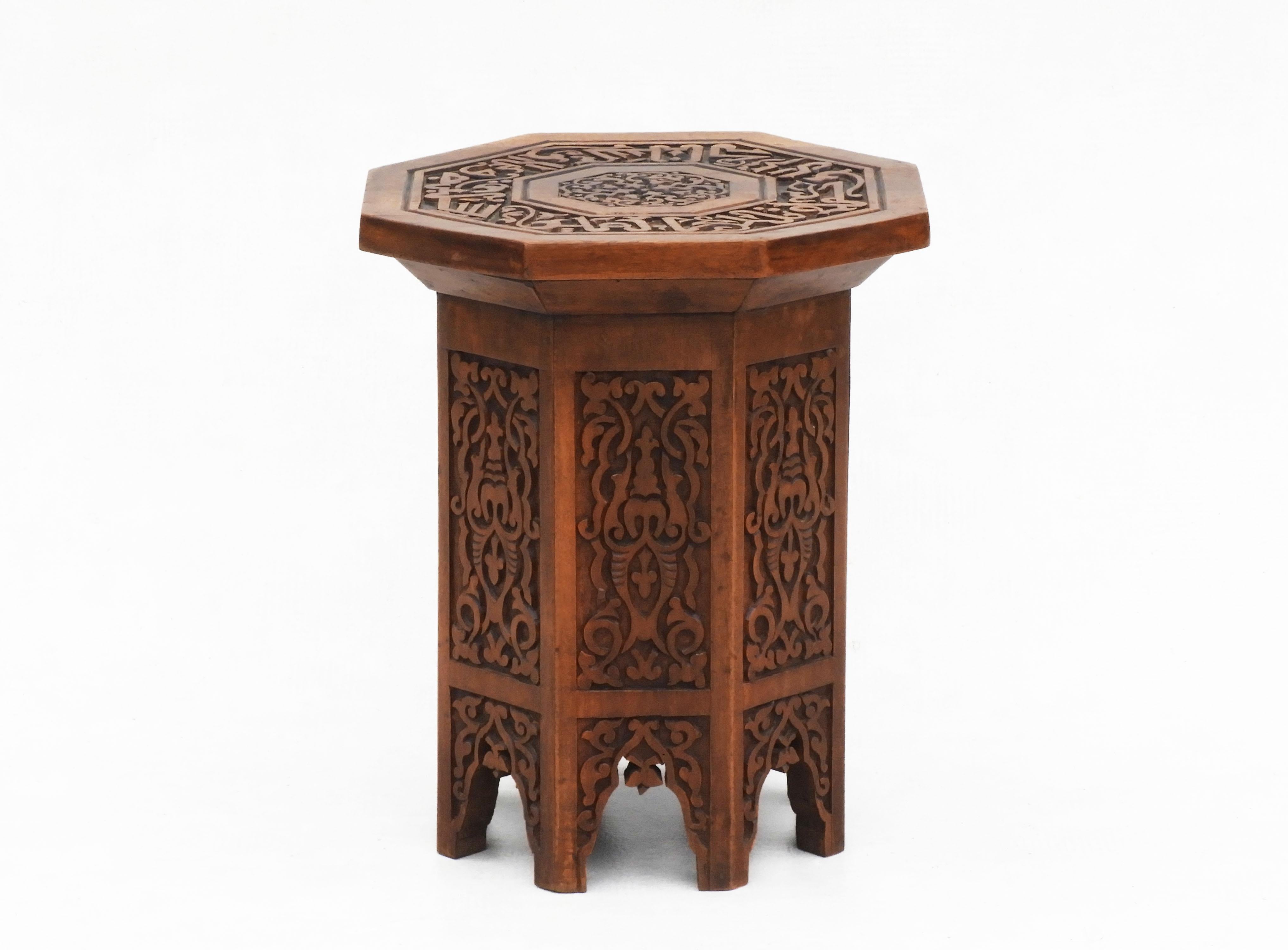 Moroccan hardwood side table or tabouret stool. Attractive arched octagonal form in deep relief with both calligraphic and Moorish geometrical designs. A nice Bohemian accent addition to any room.  In good condition, sturdy and strong with a nice