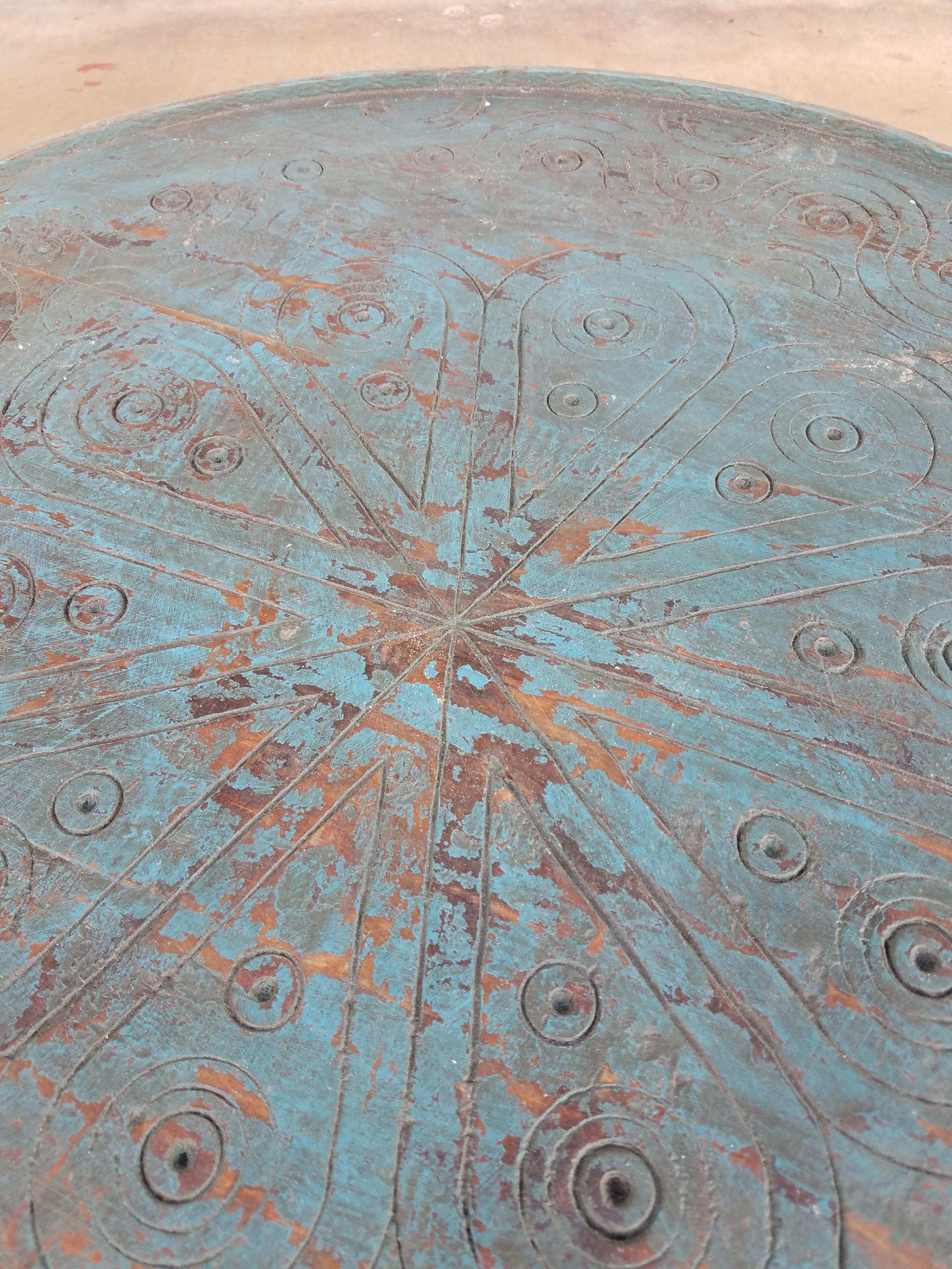 A well carved Moroccan wooden table. Circular shape and an amazing look. Color is turquoise. Coffee table height. With its detailed carving along the sides and the top, this side table will sure be a excellent add-on to your décor. It measures