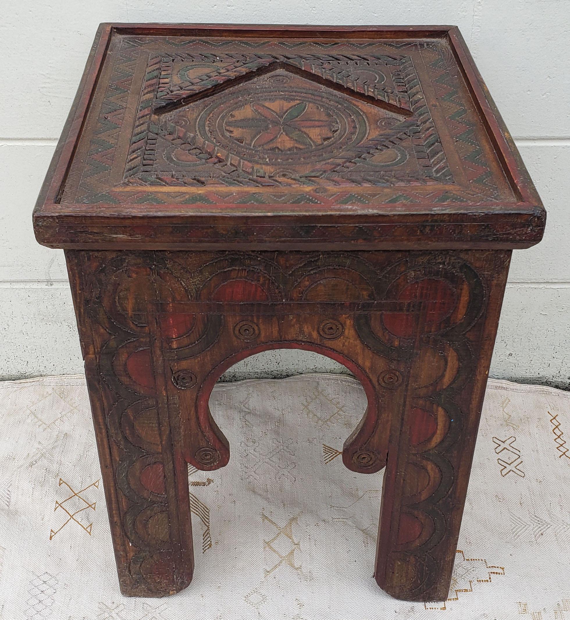 A well carved Moroccan wooden table. Square shape and an amazing look. Main color is dark brown. Side table height. With its heavy carvings along the top and the sides, this side table will sure be a excellent add-on to your décor. It measures