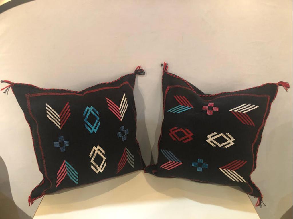 A pair of Moroccan hand-loomed wool pillows. Hand-loomed pair of pillows from the Atlas Mountains. Featuring Berber tribal original design, this pair is made of a mix of sheep and goat wool with all natural organic dyes.