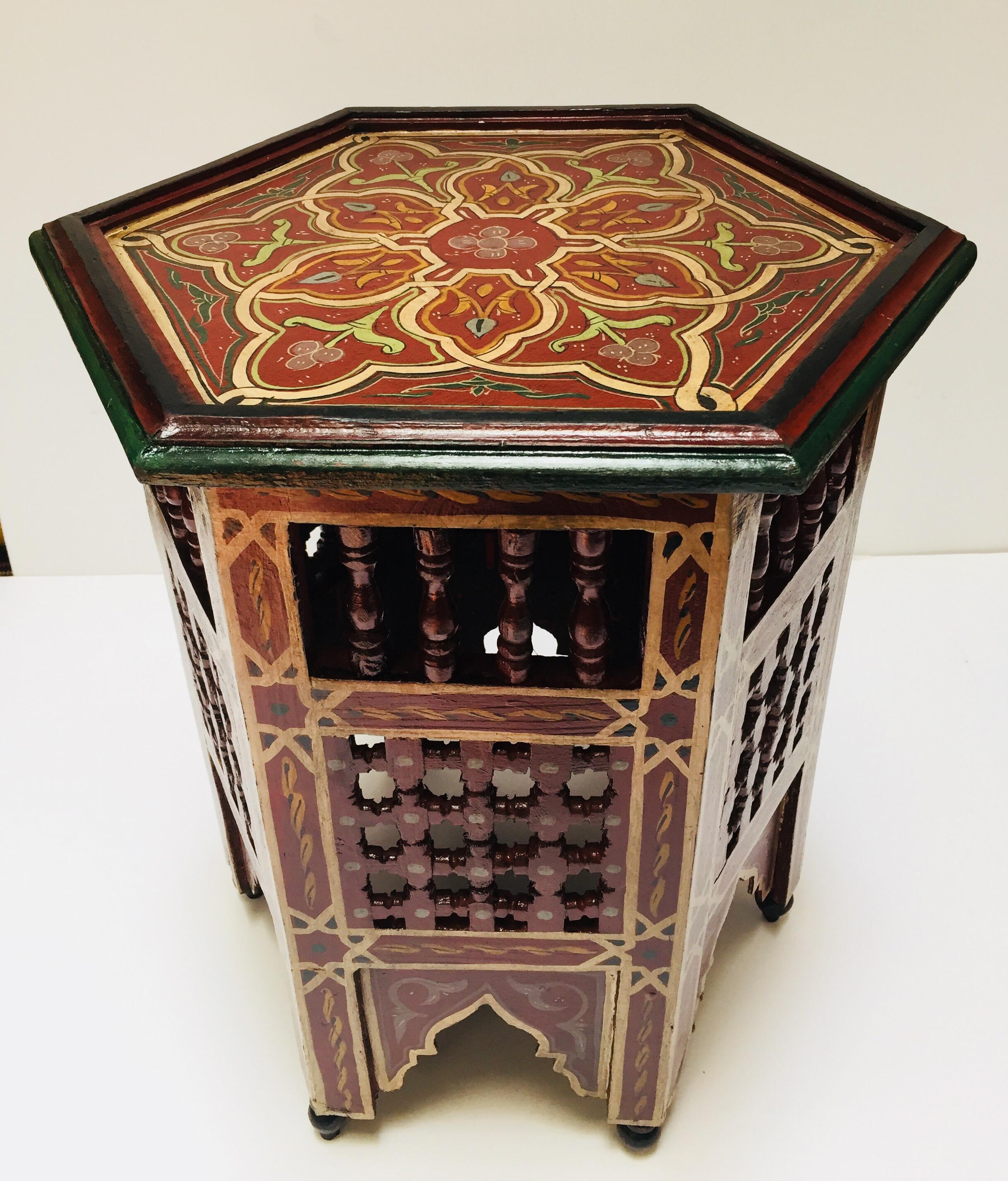 Moroccan hand-painted side table with Moorish designs.
Hexagonal shape, Moroccan vintage side table hand-painted on dark burgundy background, floral and geometric designs and moucharabieh fretwork cutout on the sides with Moorish arches.