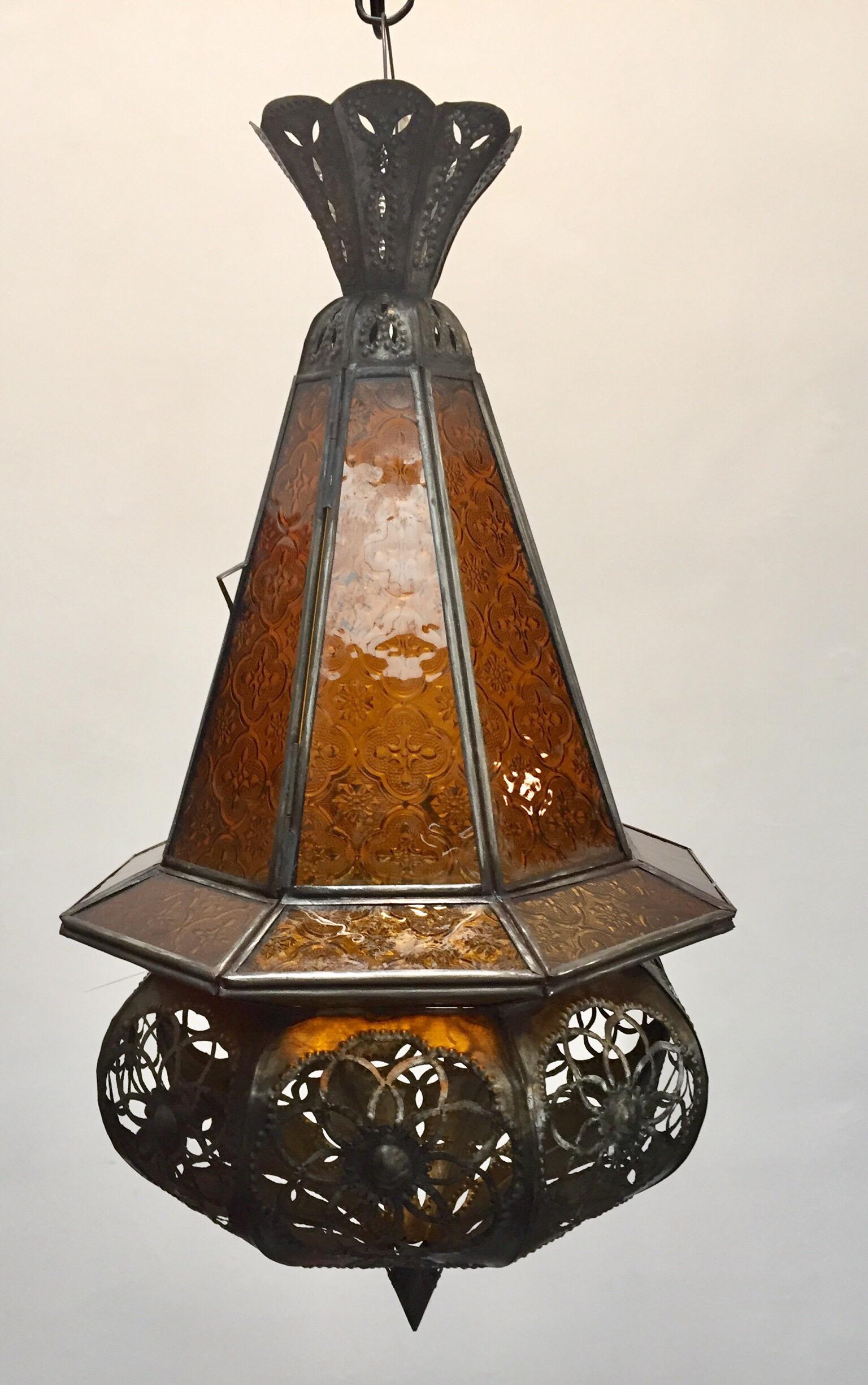 Stylish handcrafted Moroccan lantern pendant with amber molded glass and metal with an antique bronze finish. Moroccan handcrafted Moorish amber glass lantern pendant. Finely handcrafted with open metal work Moorish floral and geometric