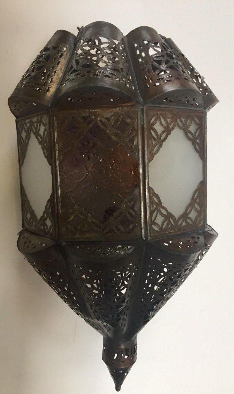 Stylish handcrafted Moroccan lantern pendant with frosted milky glass and multi-color molded glass.
Handmade with small cut-glass with Moorish filigree metal designs.
Multiple available.
Comes with a 10 feet black cord for one light bulb with switch