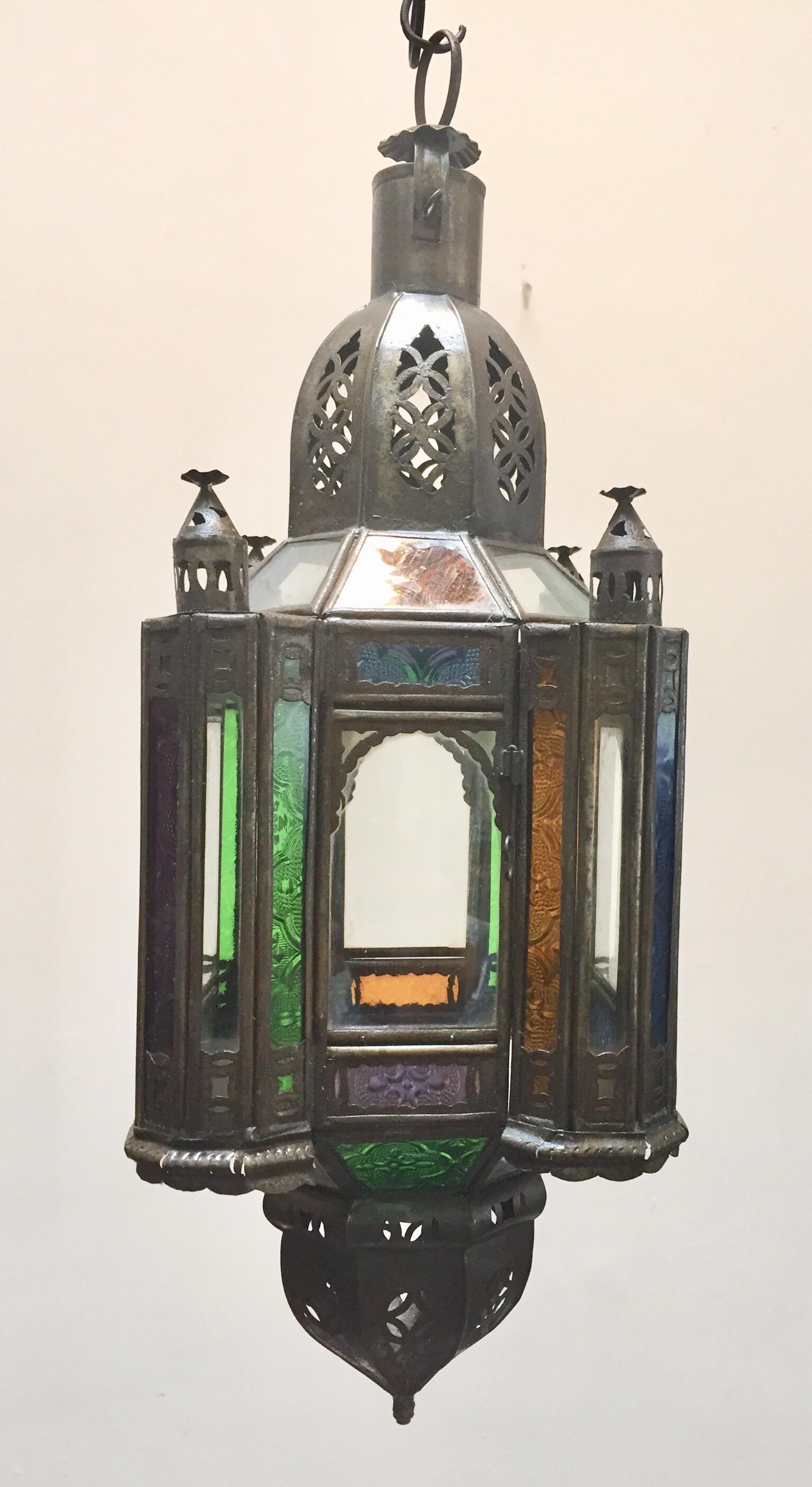 Stylish handcrafted Moroccan lantern pendant with multi-color molded glass and metal with an antique bronze finish.
Handmade with small cut-glass with Moorish filigree metal designs.
For indoor or covered area use.
About the Moroccan lanterns:
The