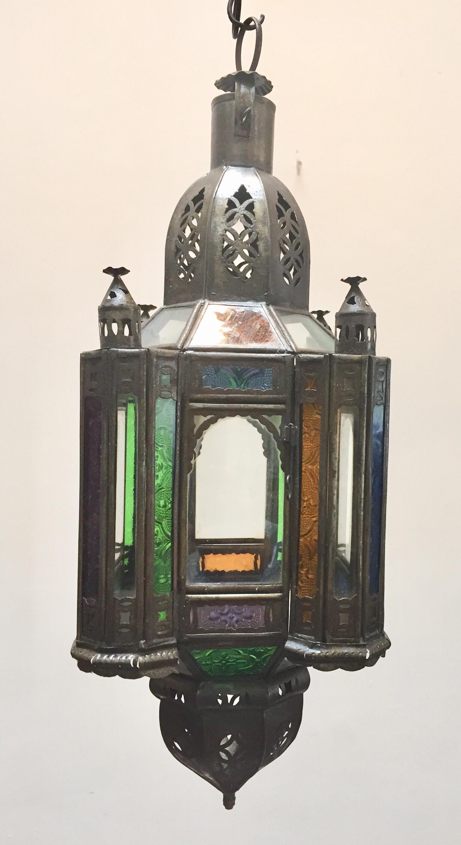 Stylish handcrafted Moroccan lantern pendant with multi-color molded glass and metal with an antique bronze finish.
Handmade with small cut-glass with Moorish filigree metal designs.
For indoor or covered area use.
Dimensions: Height: 18 in Width: