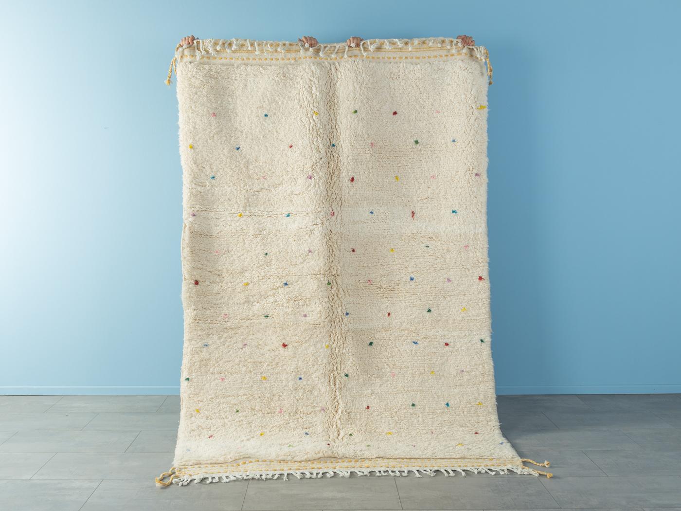 Tiny Polka Dots ist ein moderner Teppich aus 100 % Wolle - dick und weich, angenehm zu tragen. Unsere Berberteppiche werden von Amazigh-Frauen im Atlasgebirge handgewebt und handgeknüpft. Diese Gemeinschaften stellen schon seit Tausenden von Jahren