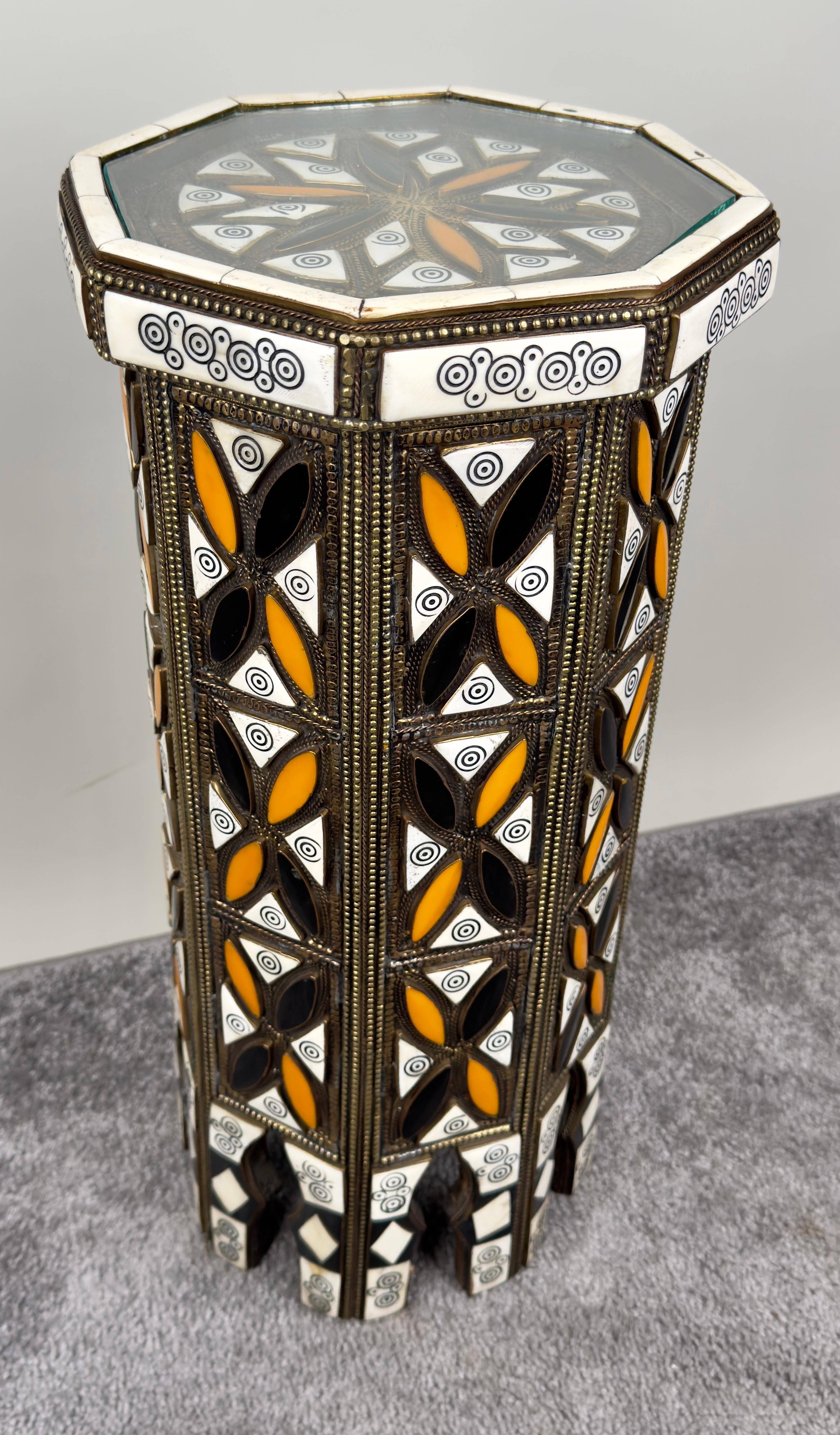 The Moroccan handmade small side table embodies a rich fusion of cultural motifs and meticulous design. Its octagonal shape lends it an air of geometric precision with  the surface adorned with intricate patterns. The tabletop is a mosaic of