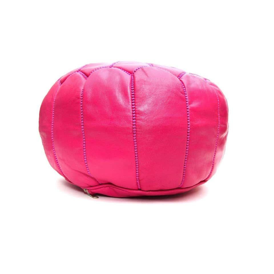 This eye-catching handstitched genuine hot pink leather pair of Moroccan poufs will lend an air of regal majesty to your den or living room. Handcrafted in leather by master artisans and boasting a resplendent arabesque pattern, this pair of poufs
