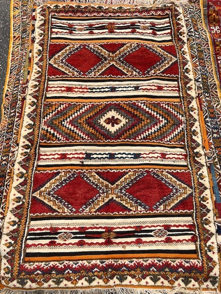 Elevate your living space with this exquisite handwoven Moroccan tribal rug. Crafted from premium organic wool by skilled women artisans in the Atlas Mountains, its bold diamond pattern and abstract design elements exude timeless elegance and