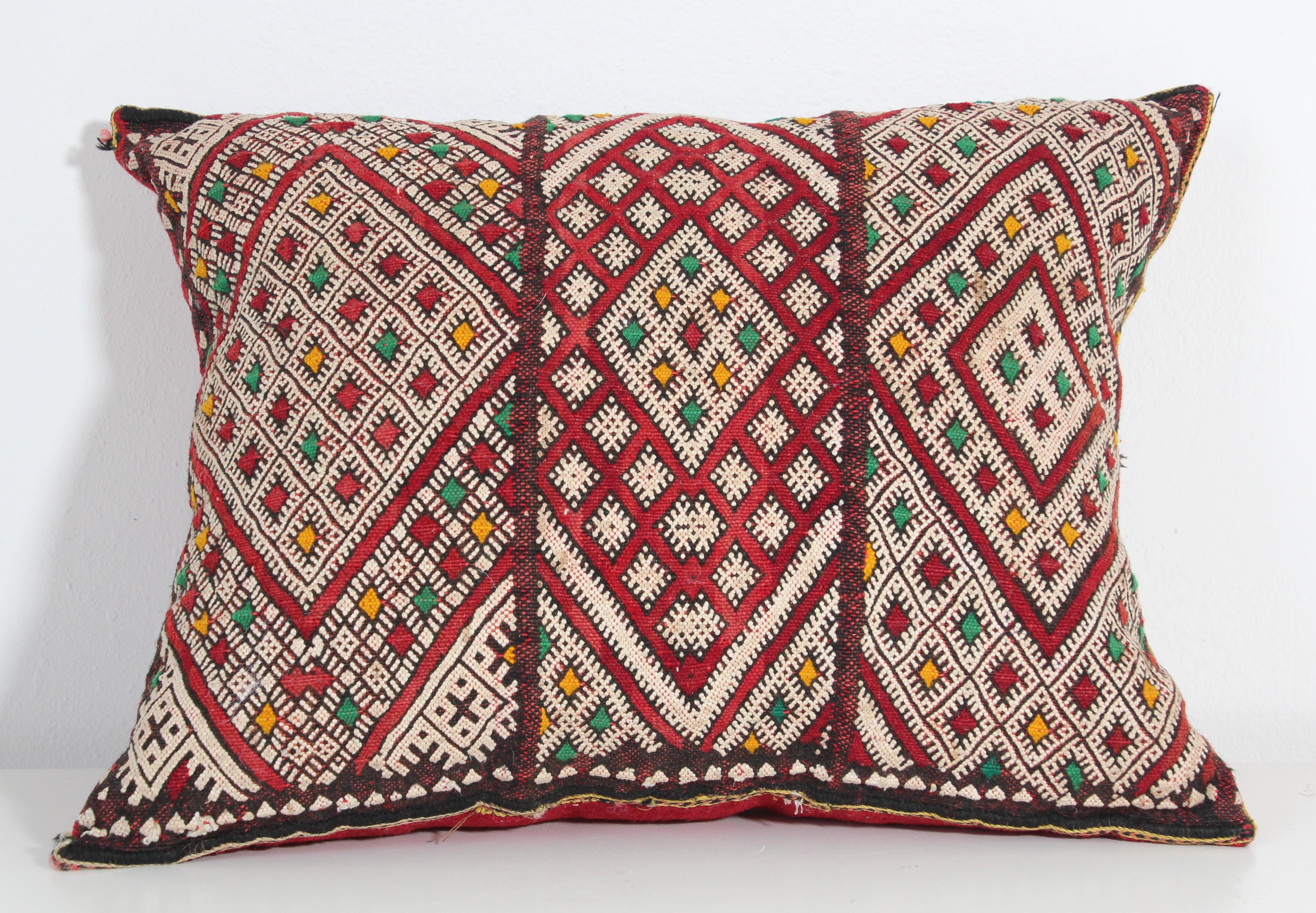 Moroccan Berber handwoven tribal throw pillow made from a vintage rug.
The front and the back are made from a different rug, front is more elaborate and back is more plain.
Geometric African tribal designs in red, white and black and some green