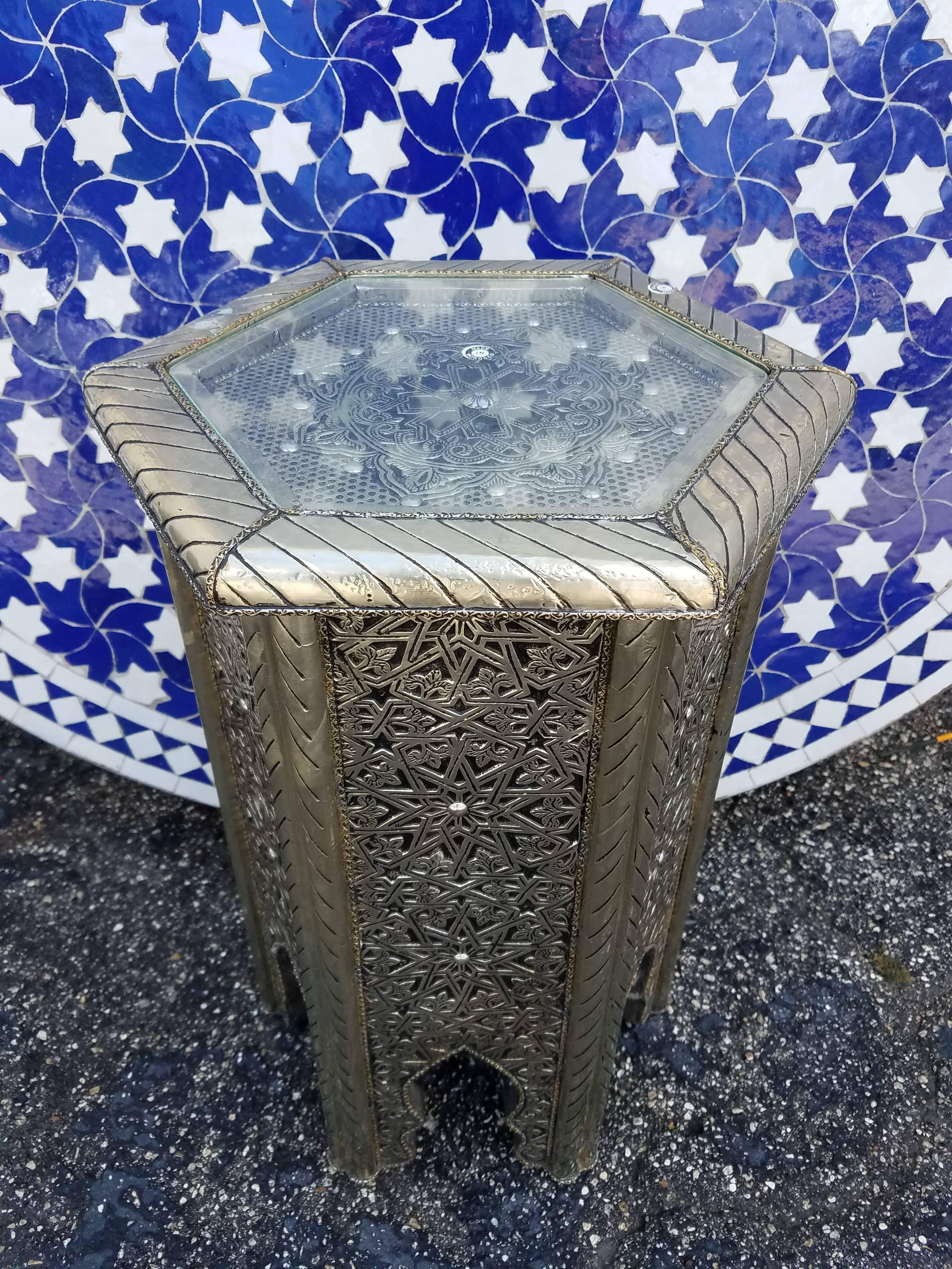 Very exotic hexagonal all metal inlaid Moroccan side table. With its detailed carving along the sides and the top, this side table will sure be a excellent add-on to your décor. It measures approximately 20” in height and 12