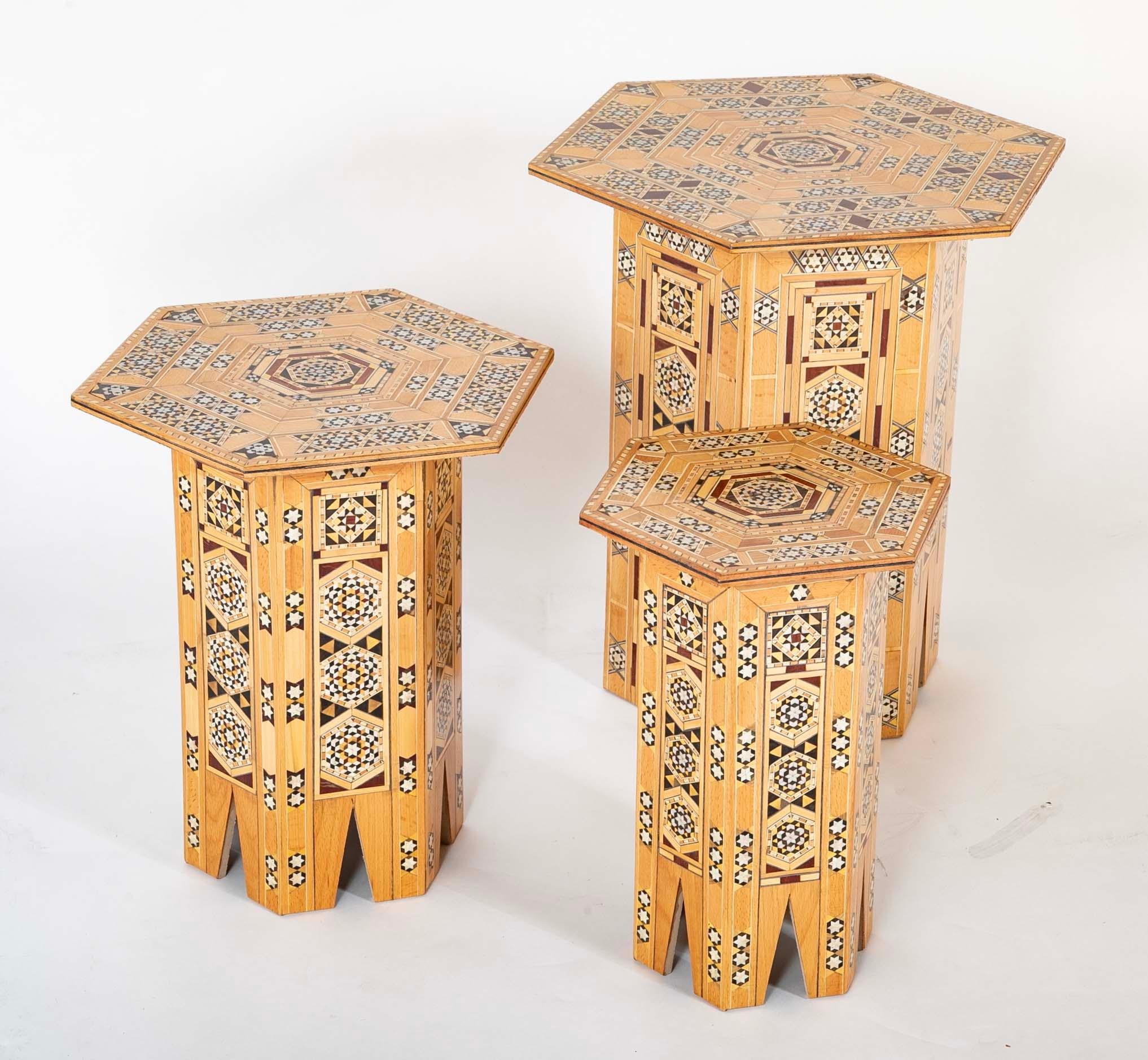 Set of three Moroccan hexagonal inlaid side tables in graduated sizes. This eye catching  group of side or drinks tables are a fun addition to any room. With intricate geometric inlay of polished bone and various hard woods and fruit woods in the