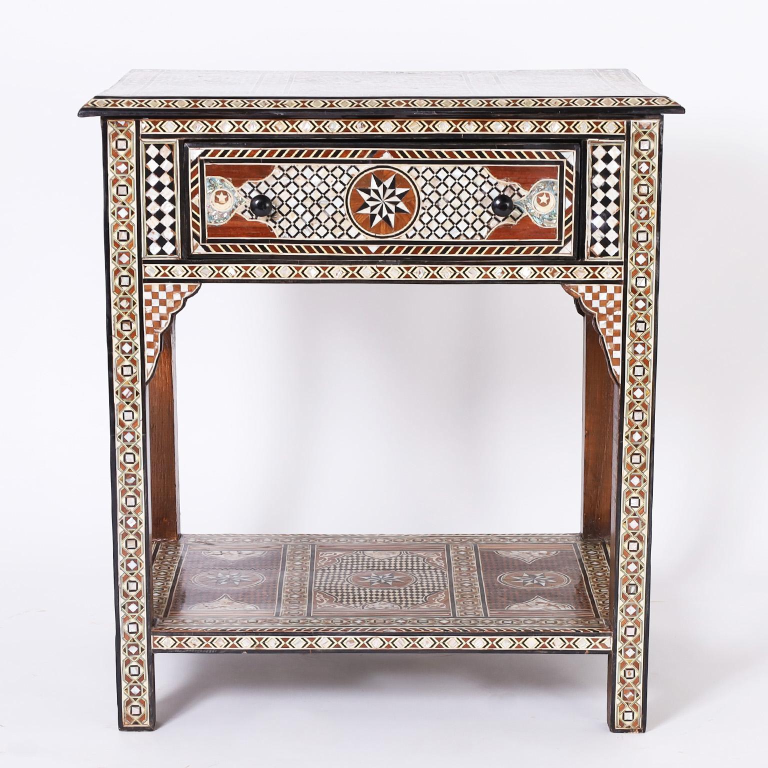 Moroccan table or stand crafted in indigenous hardwoods decorated all around with mother of pearl, mahogany, ebony and bone in elaborate inlays and marquetries with one drawer when removed reveals four secret compartments.