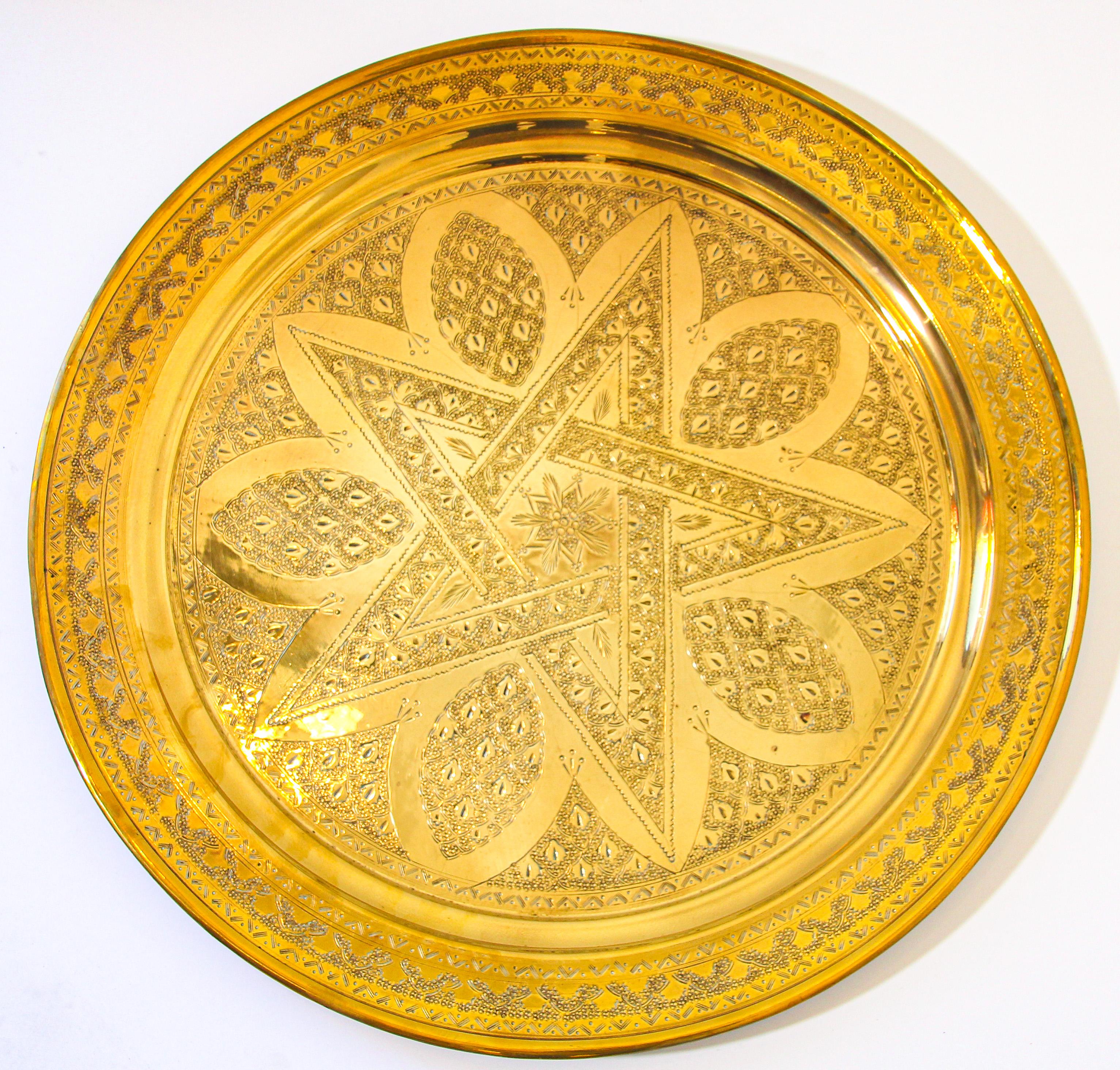 Antico vassoio marocchino del 1900 in ottone martellato a mano, intricata opera d'arte, raffinata lavorazione islamica in ottone con disegni incisi a mano e una stella a cinque punte al centro.
Vassoio decorativo in ottone lucido realizzato a